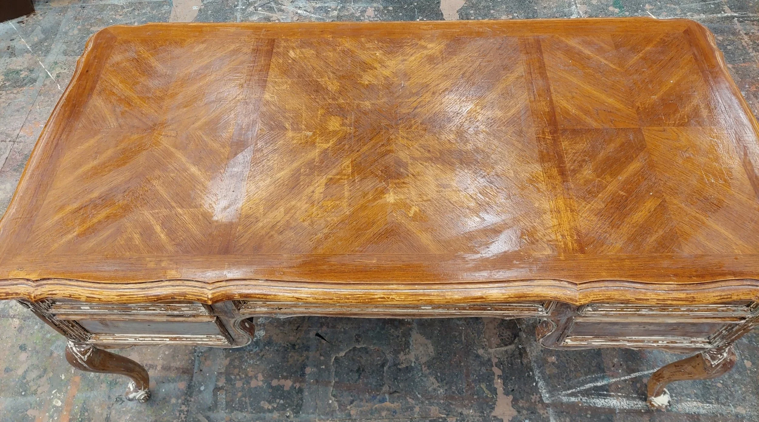End of day 4. The top after the first round of scraping revealed the inlay. This was the easiest step since it is a flat surface and the coats of paint were much more even. Shows the original varnish, minus the scratching/dust because it was still da