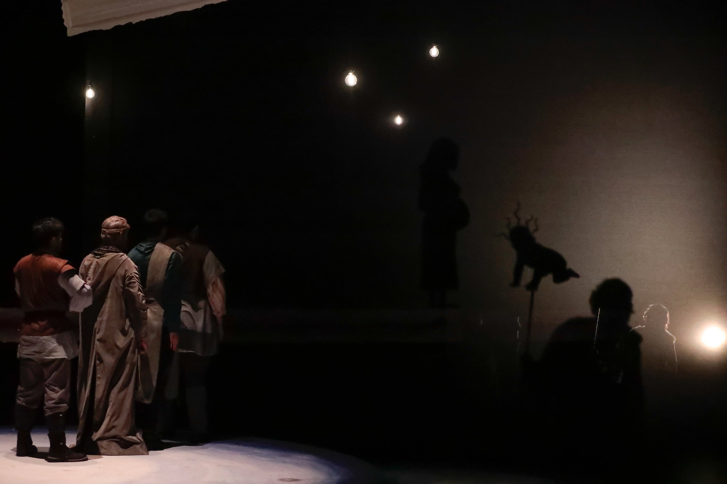 Demon baby shadow puppet with actors for scale. Projected puppets appear very large, but are actually no larger than 18".
