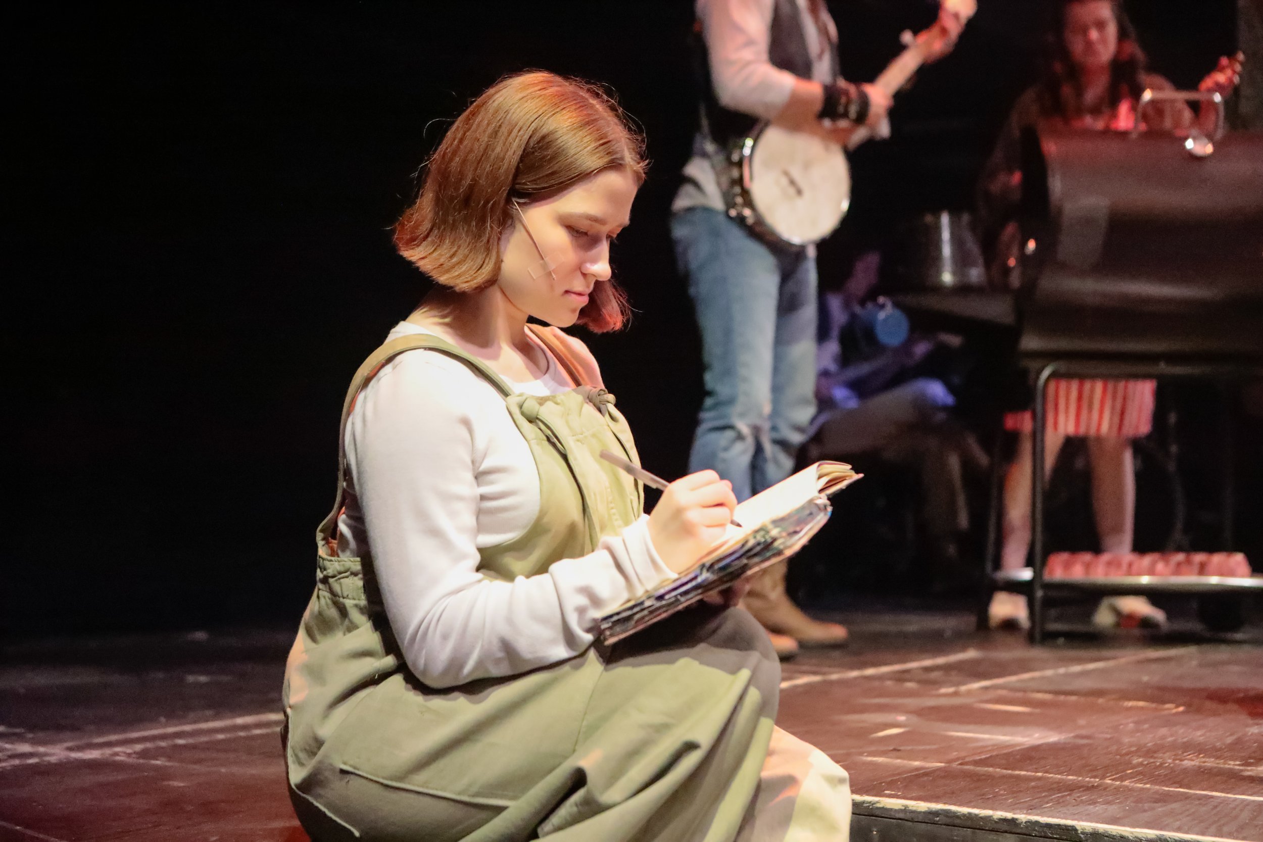 Jacques' use of the notebook onstage. In the background, the grill (purchased) and meats (built by shop.) Production photo by Sorcha Auguestine