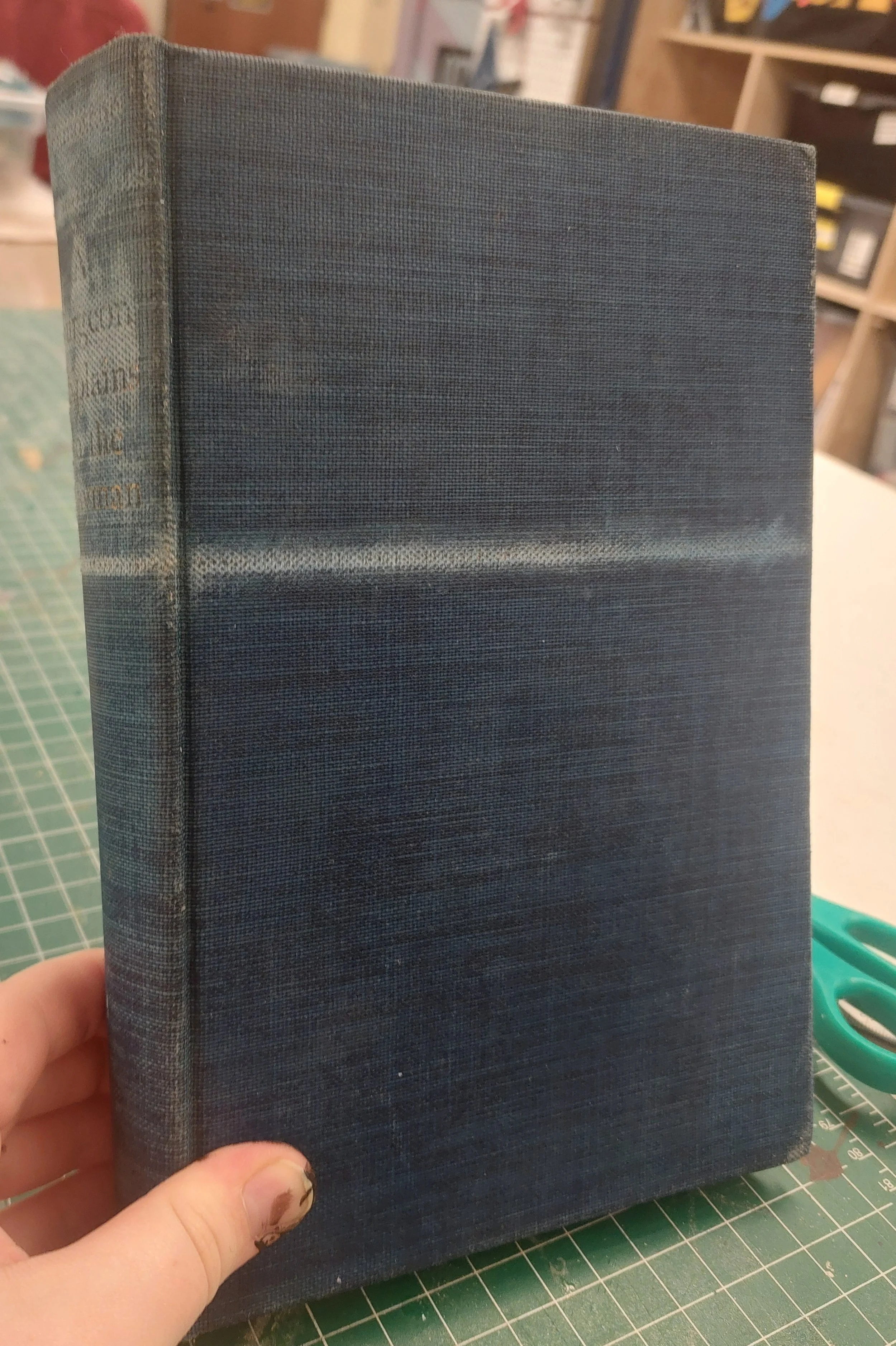 Started the new book by removing some pre-existing gold decoration and then removing, stabilizing, and reattaching the cover to make it more sturdy. Used bookbinding supercloth, spray adhesive, chipboard, and rubber cement to ensure longevity for the
