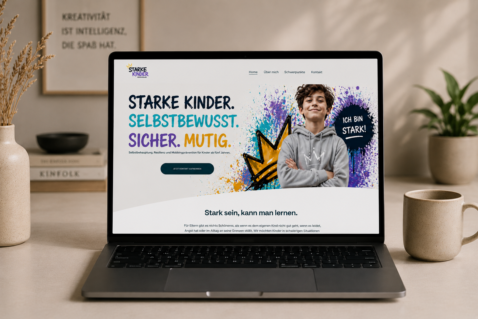 Laptop mit Webseite für ein Kinderprogramm, das Spaß, Selbstbewusstsein, Sicherheit und Mut fördert, mit einem lachenden Jungen und buntem Graffiti-Design.