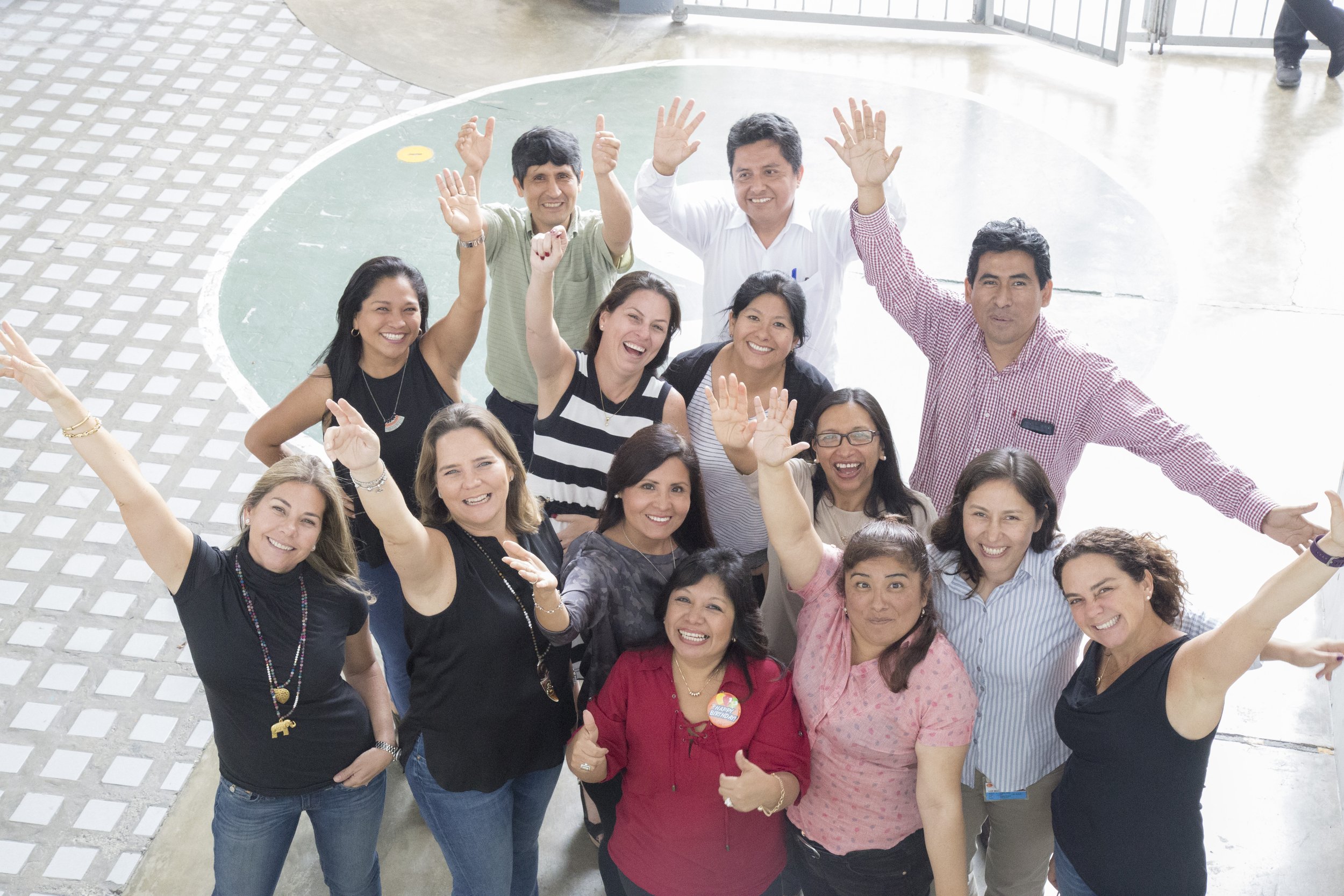 Group of diverse people smiling and raising hands