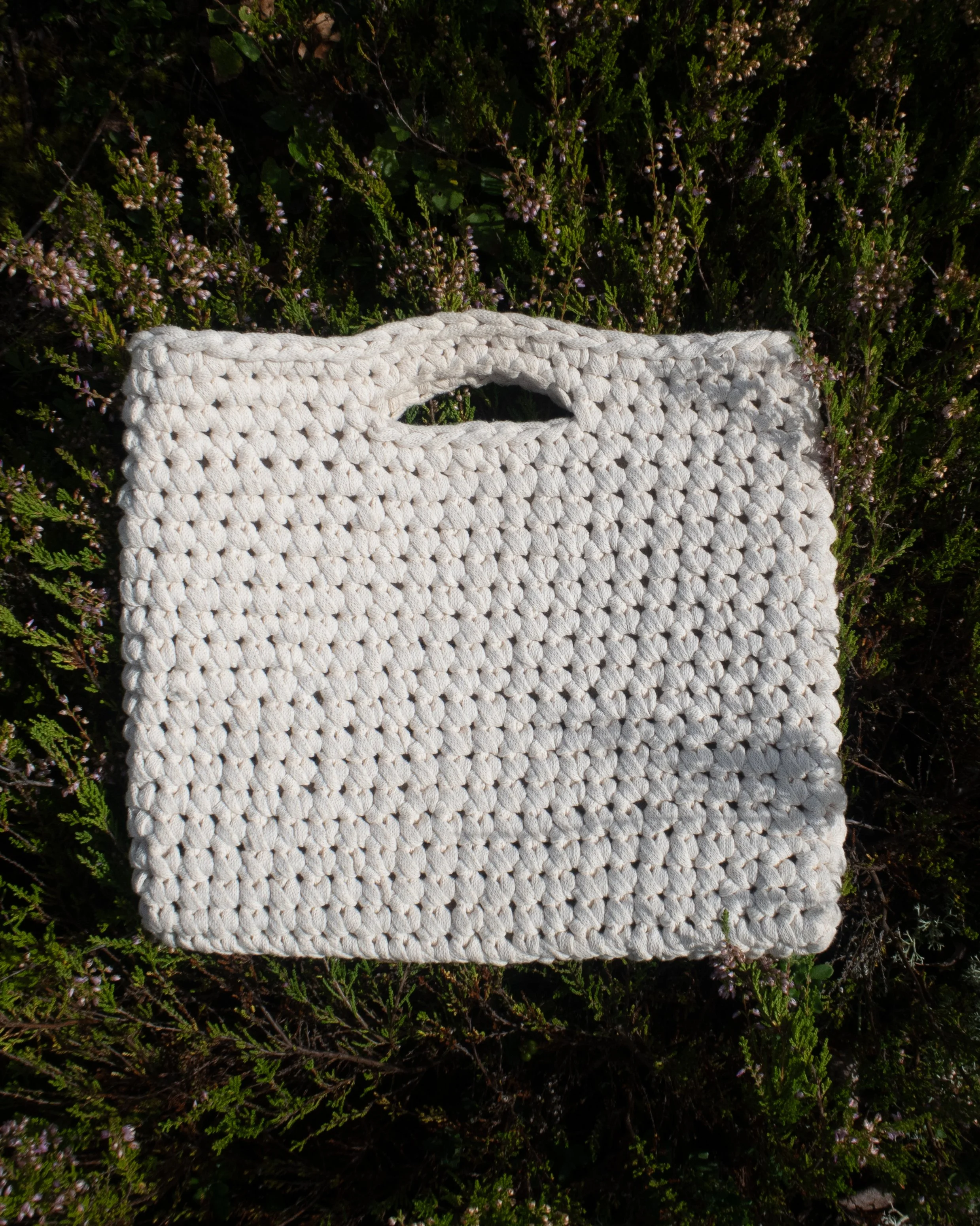 Calluna sleeve. Luonnonvalkoinen, virkattu laukku, kädensijoilla.