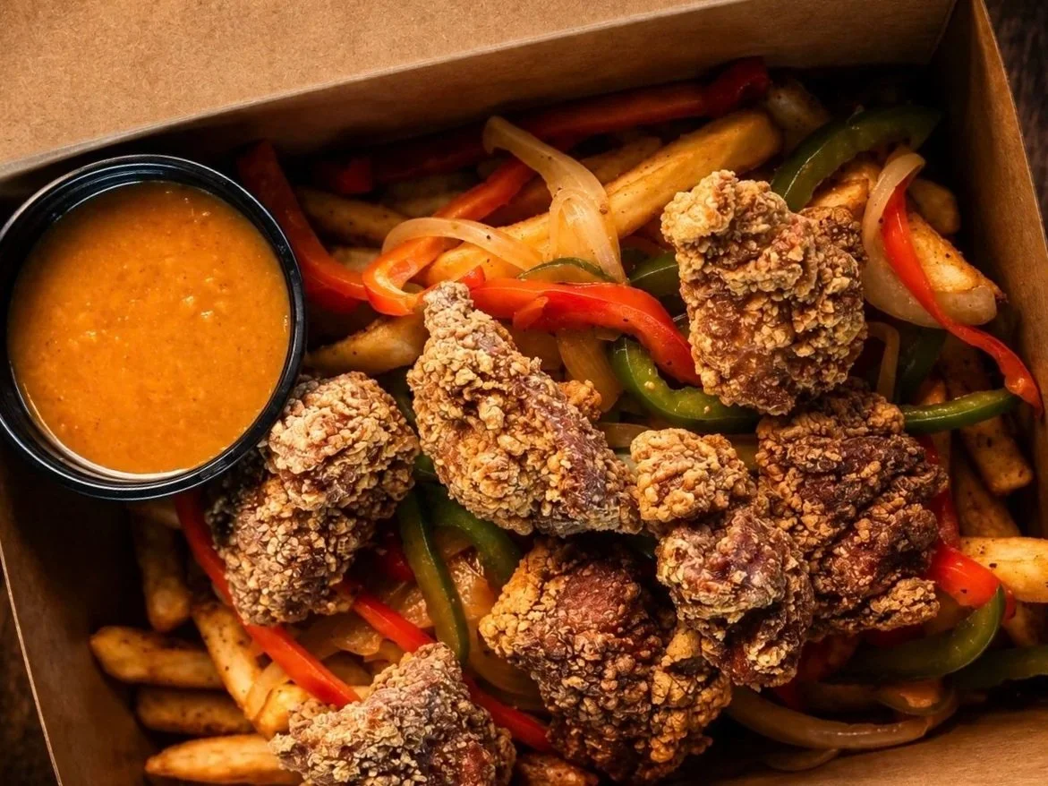 karaage irish spice dish loaded with french fries, sauteed peppers and onions, karaage chicken, and curry sauce