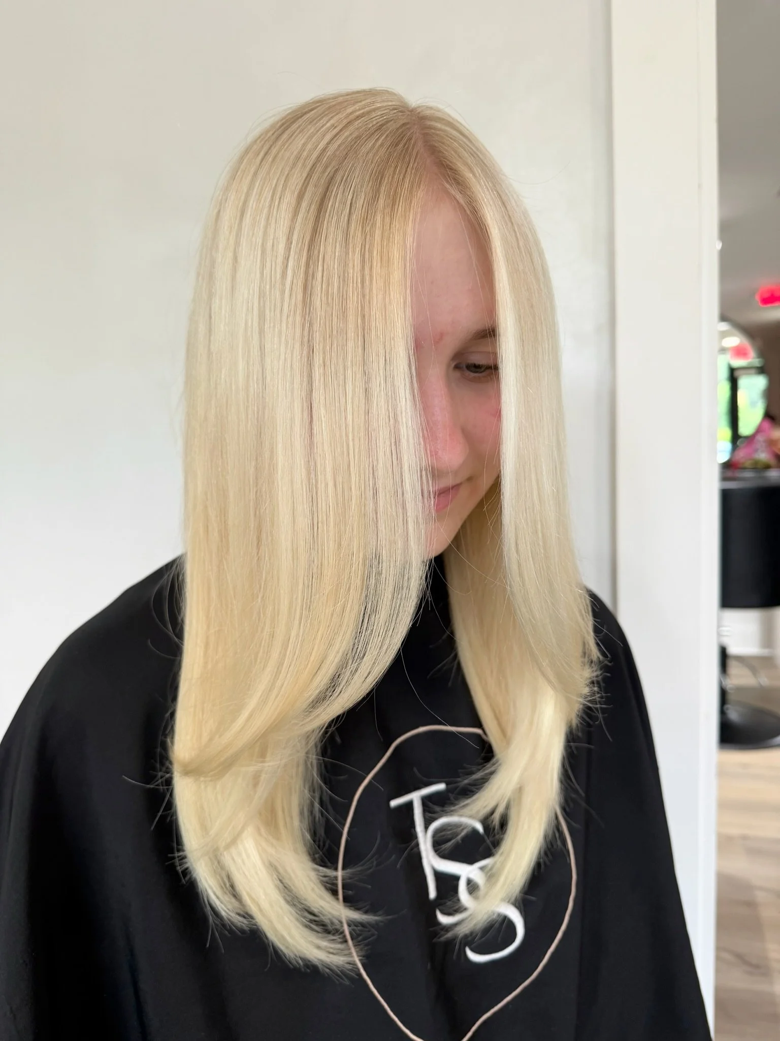 A woman with long, straight, platinum blonde hair at a salon.