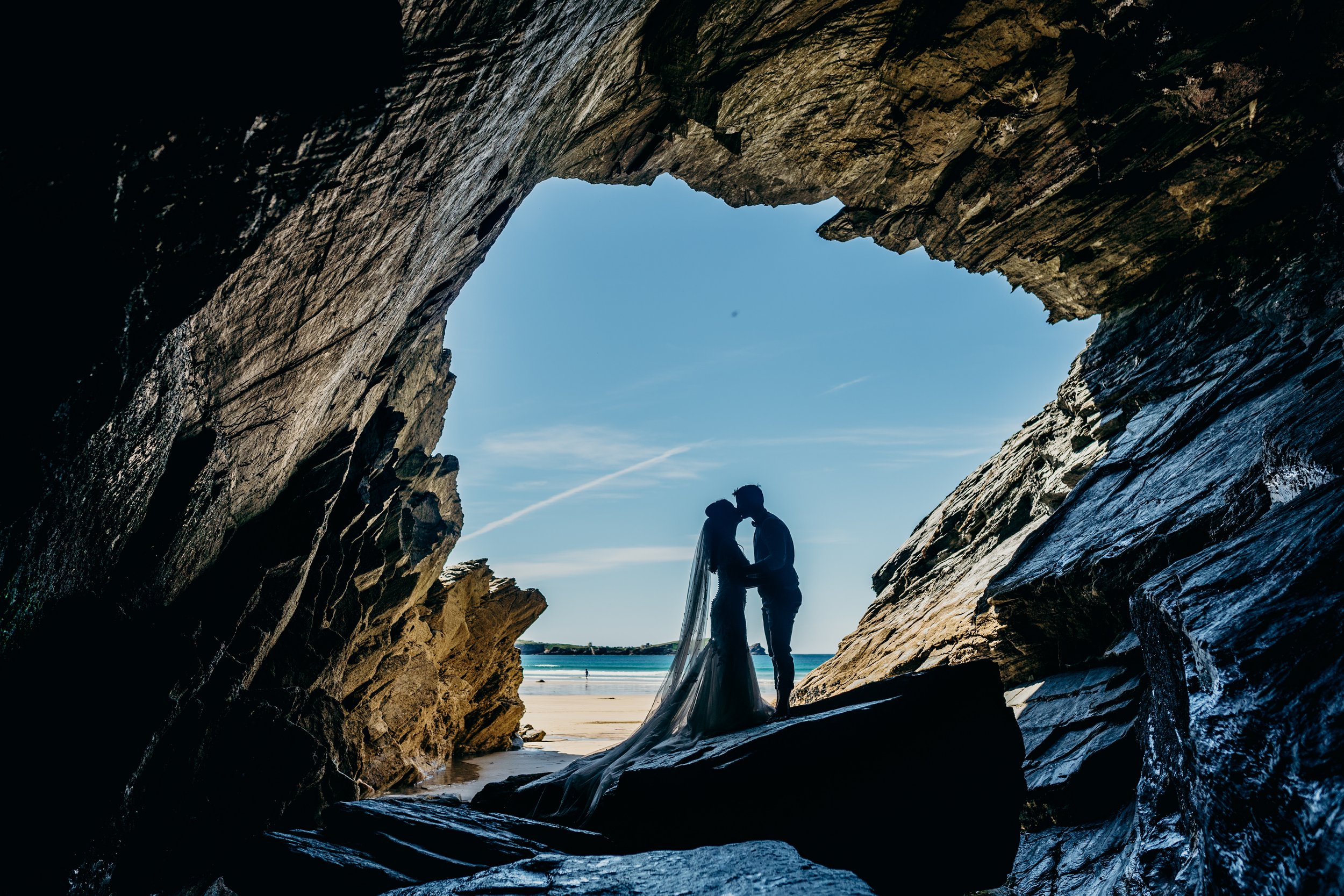 Couple kissing under cave at the beach