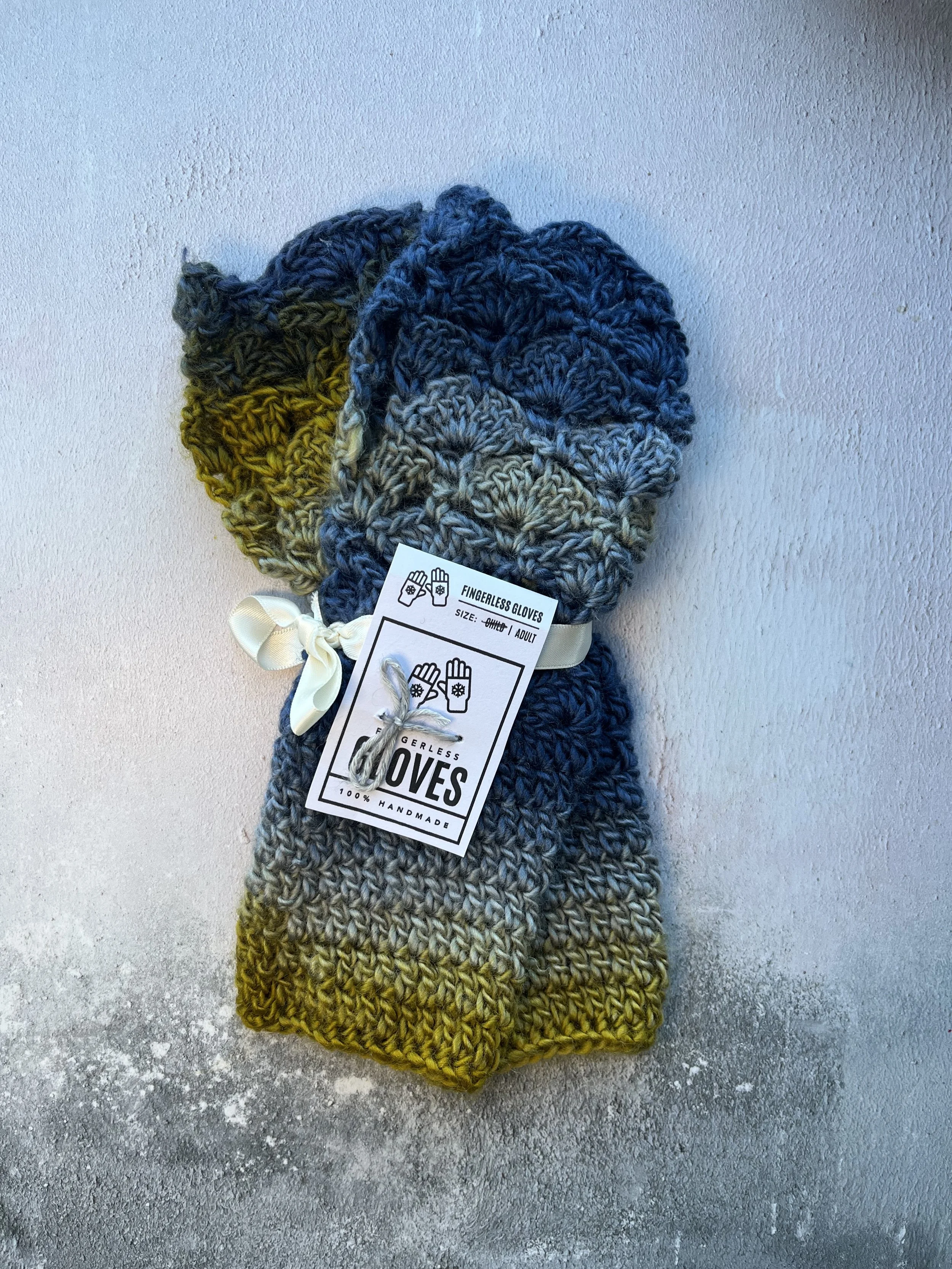 Crochet fingerless gloves in cool colours of blue and yellow green. Made with acrylic yarn in a subtle colour transition
