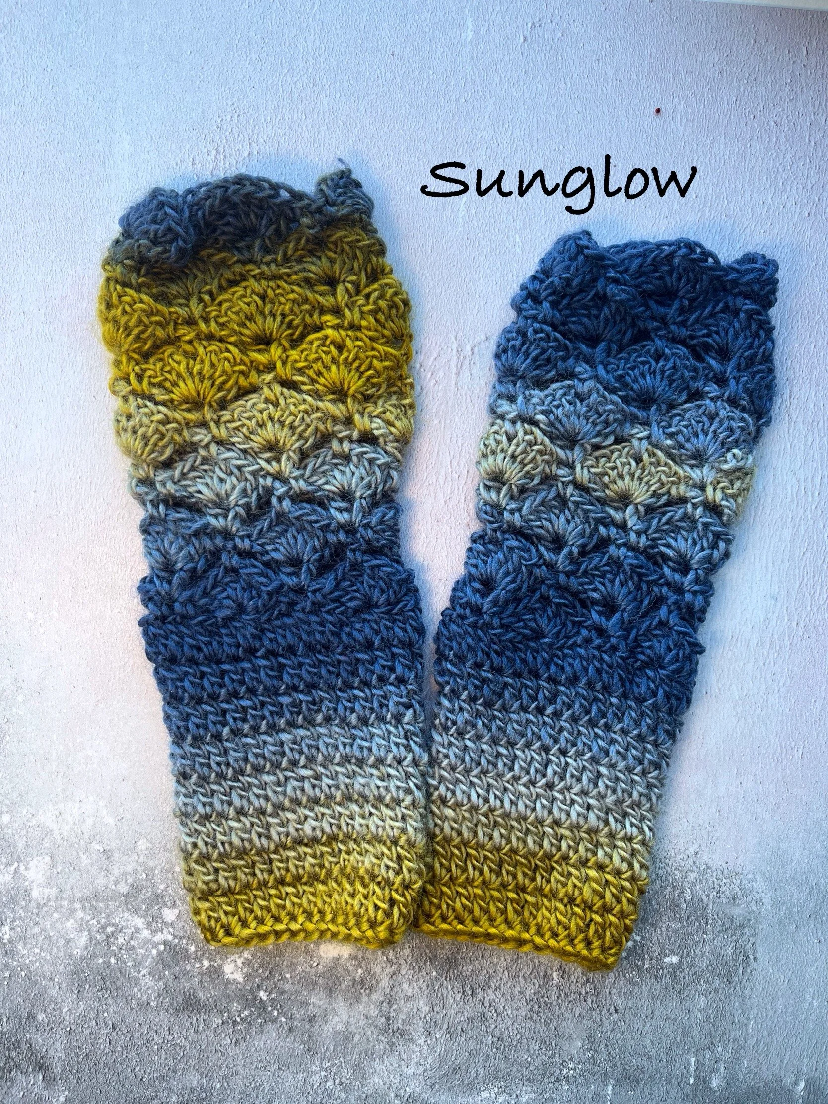 Crochet fingerless gloves in cool colours of blue and yellow green. Made with acrylic yarn in a subtle colour transition