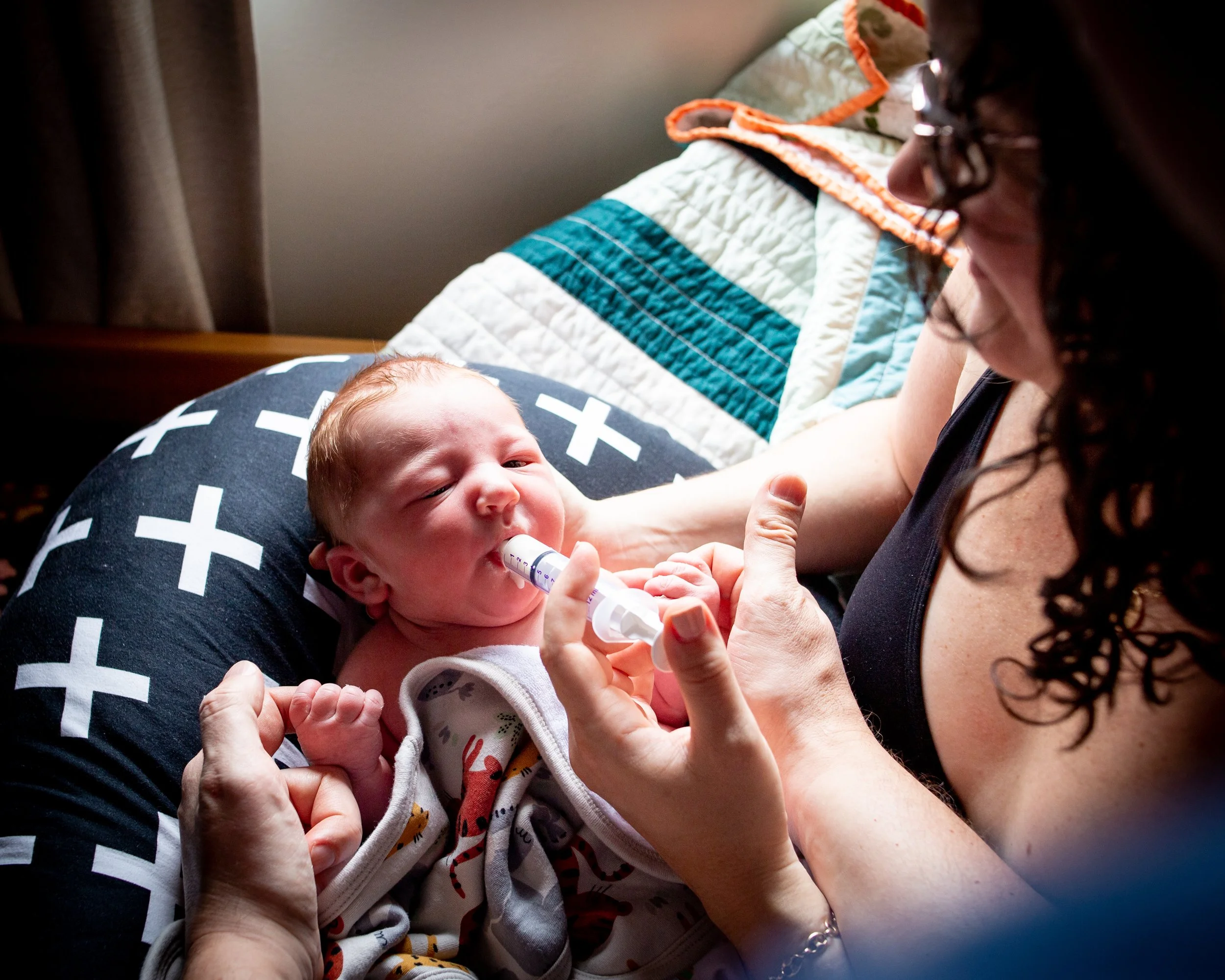 Newborn baby being fed by syringe.