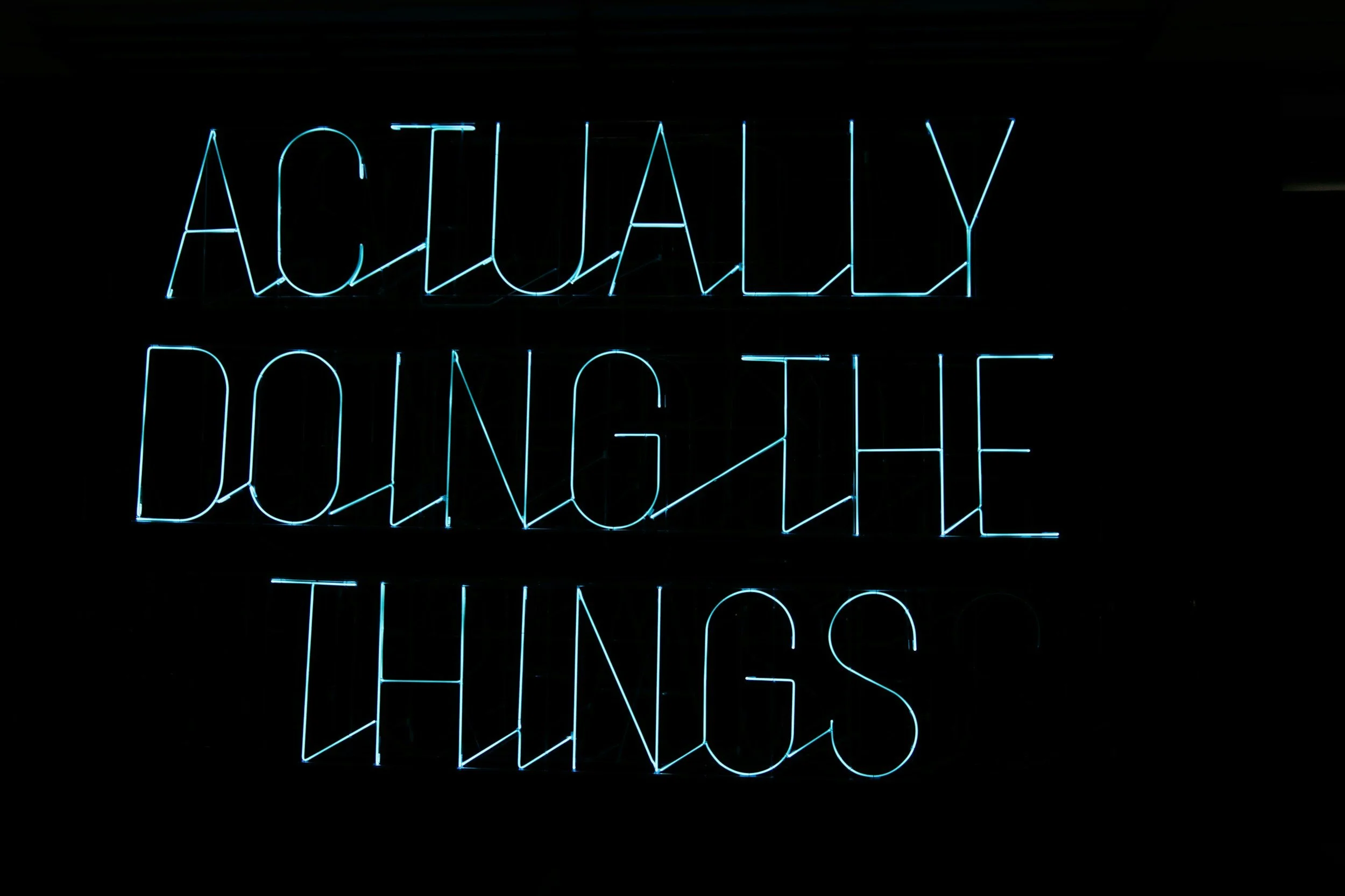neon lights image of "Actually Doing the Things" sign