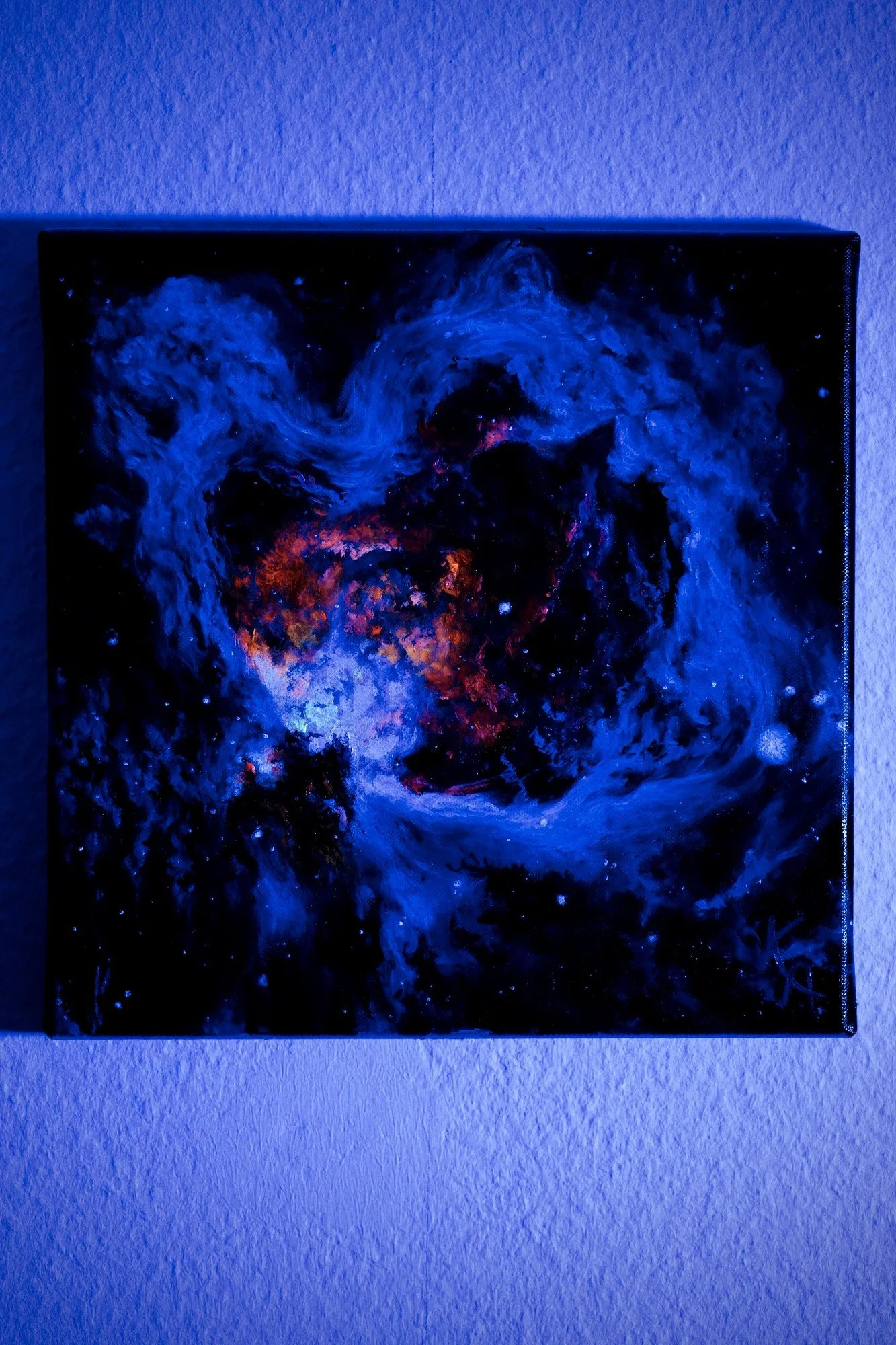 Glow-in-the-dark nebula painting photographed under blacklight, showing luminous glowing stars