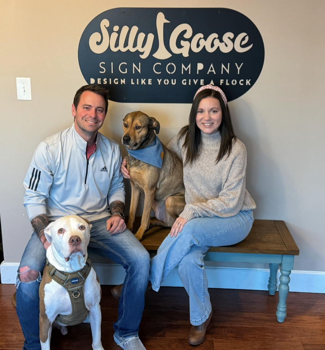 Owners of Silly Goose Sign Co. pose with their dogs