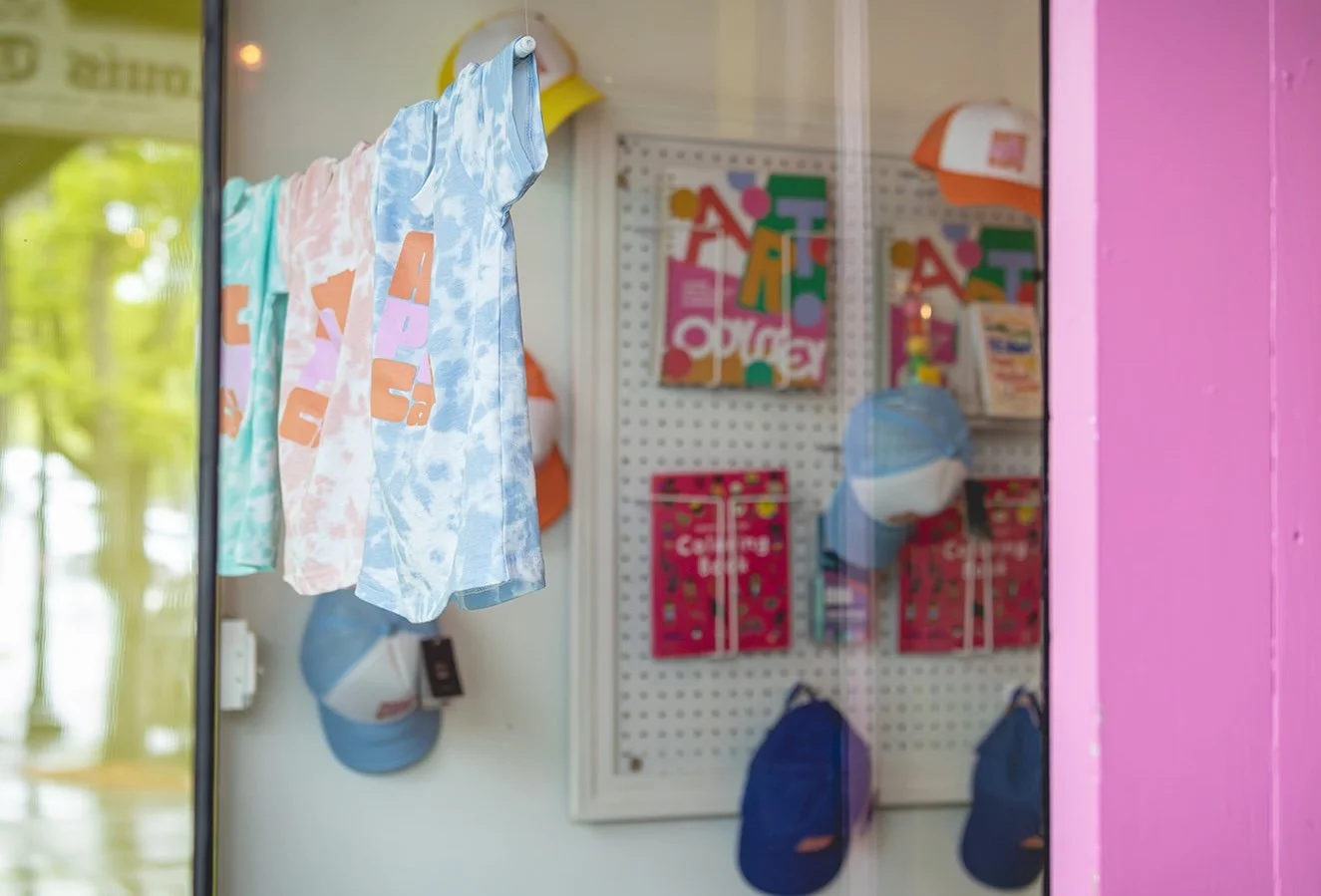 A view of the merch and art on the wall through the café window.
