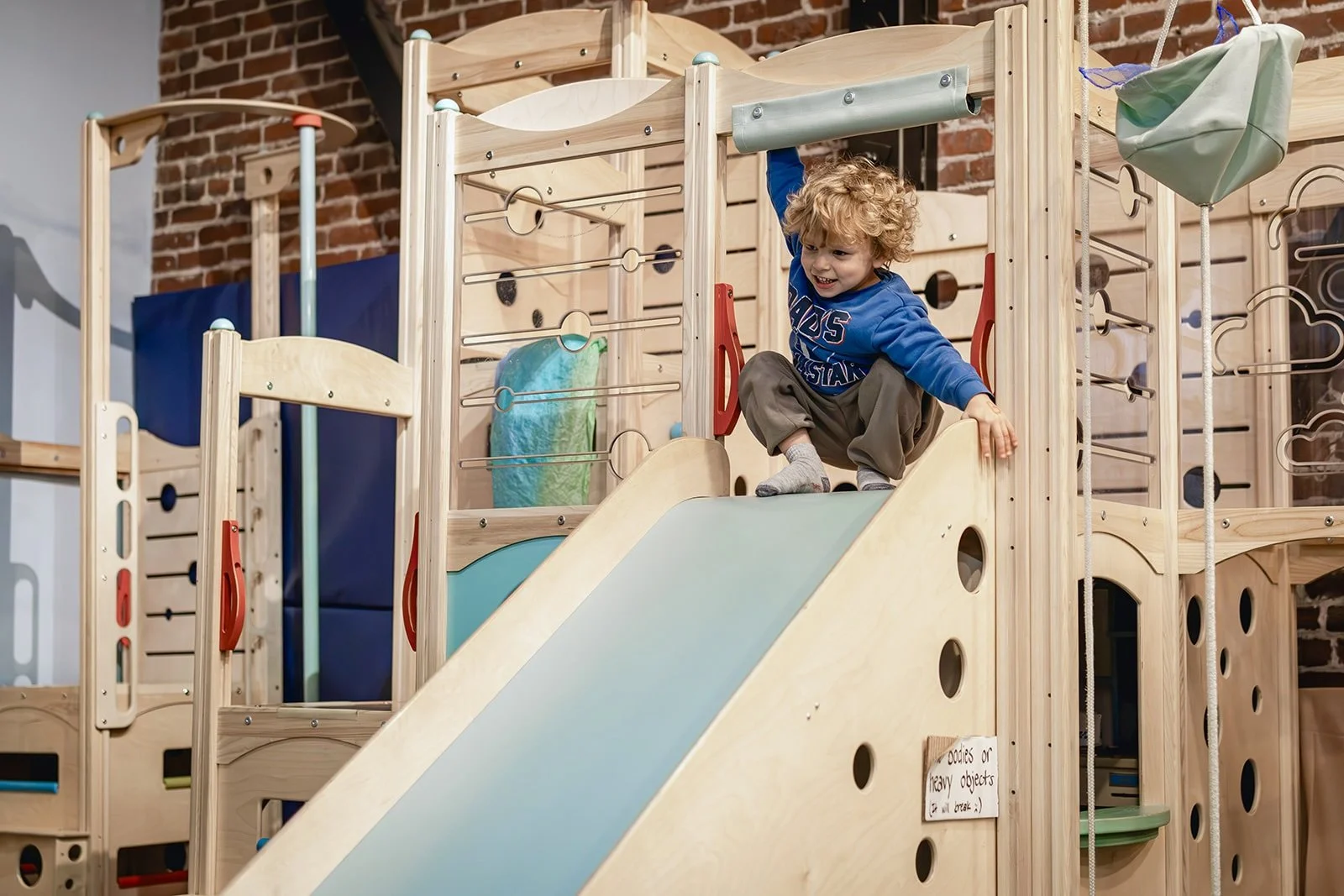 Child getting ready to go down the slide in the playroom at Art Play Café.