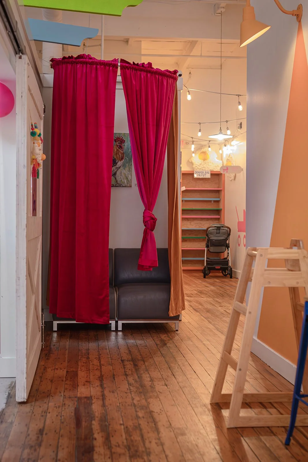 Cozy curtained nursing corner with stroller parking at Art Play Café