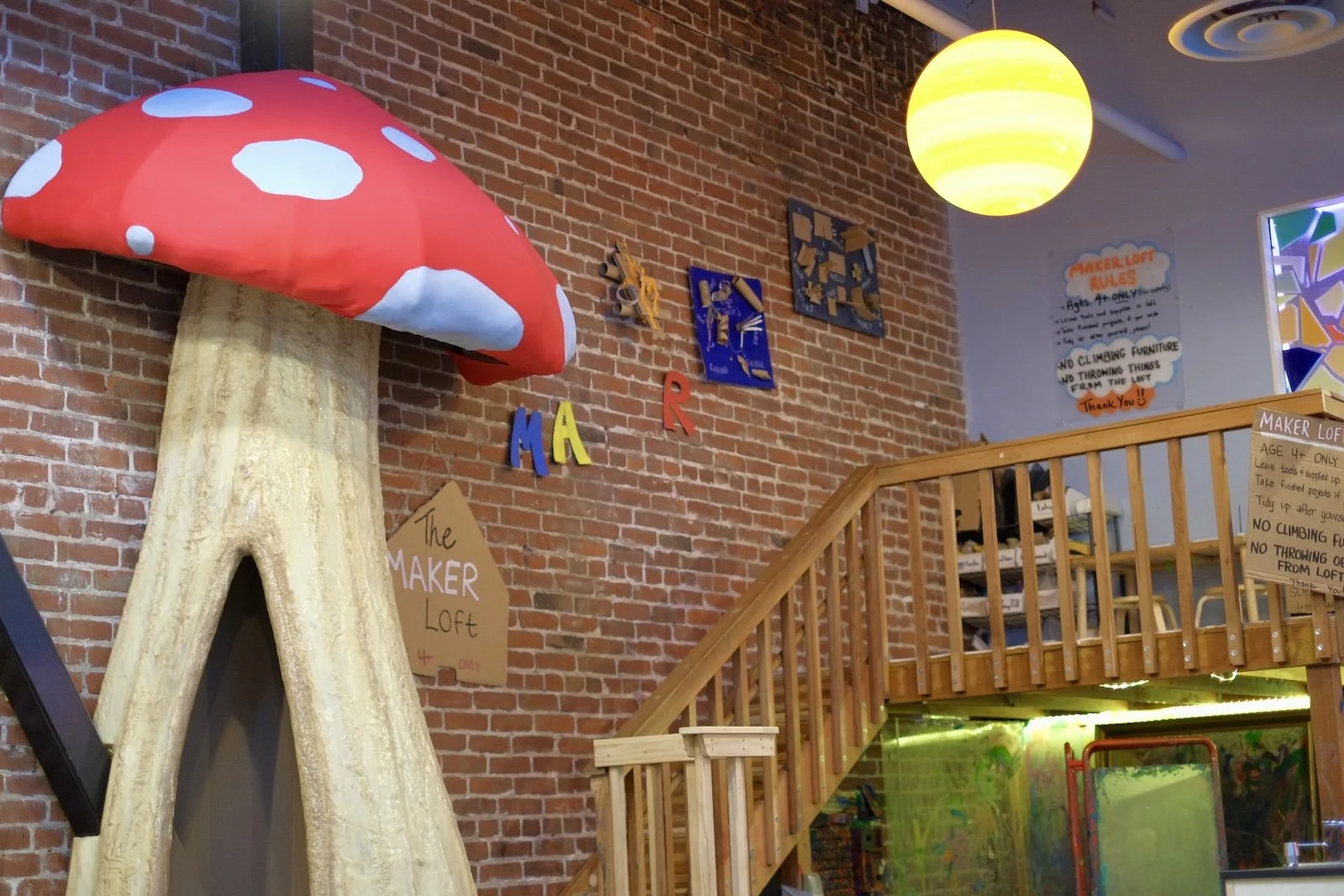 Whimsical mushroom decor next to the stairs leading up to the maker loft