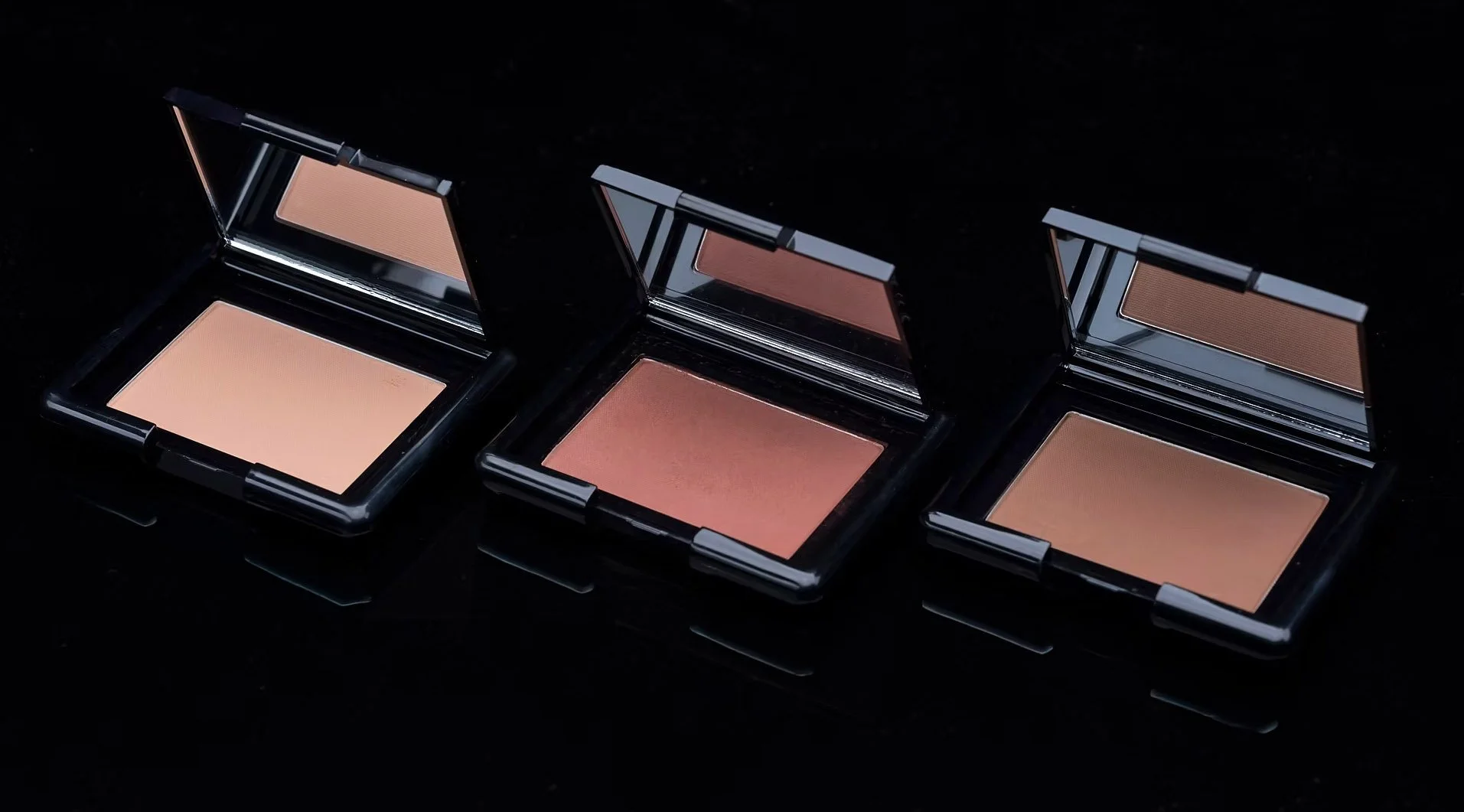 Eye shadow products on a black reflective surface