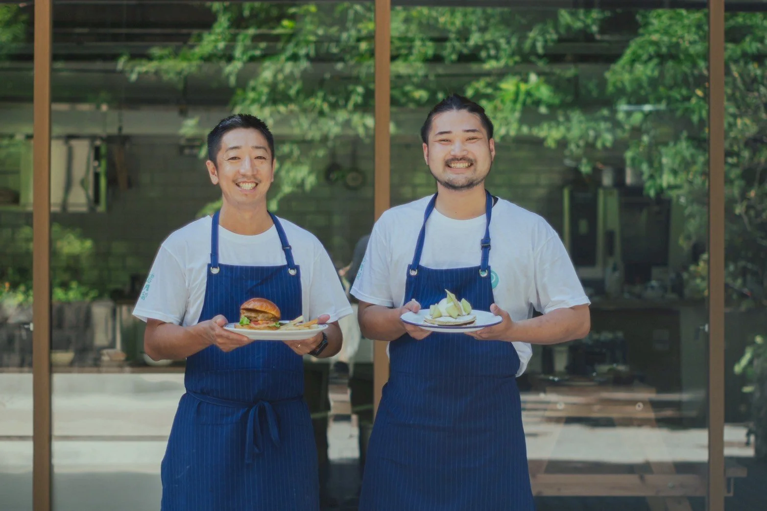 Two chefs from Pebble posing outside the restaurant with food.
