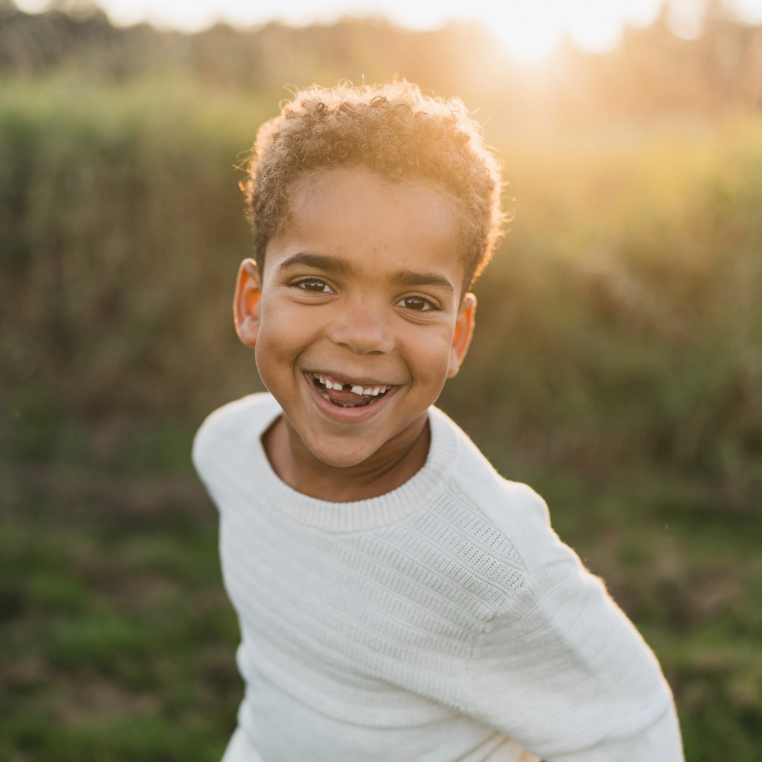 A gap toothed child is smiling brightly for his family photo at Marymoor Park, just outside Seattle. 