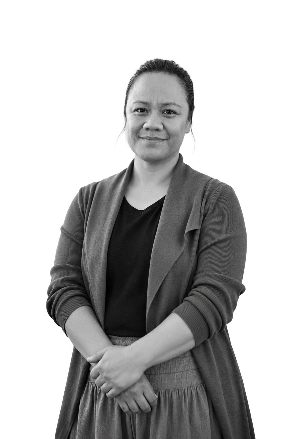 A black and white portrait of a woman standing with her arms crossed, wearing a blazer over a t-shirt, smiling slightly in front of a plain background.
