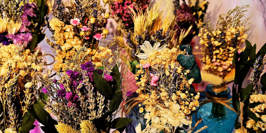 Various colorful dried flowers in vases and bouquets.