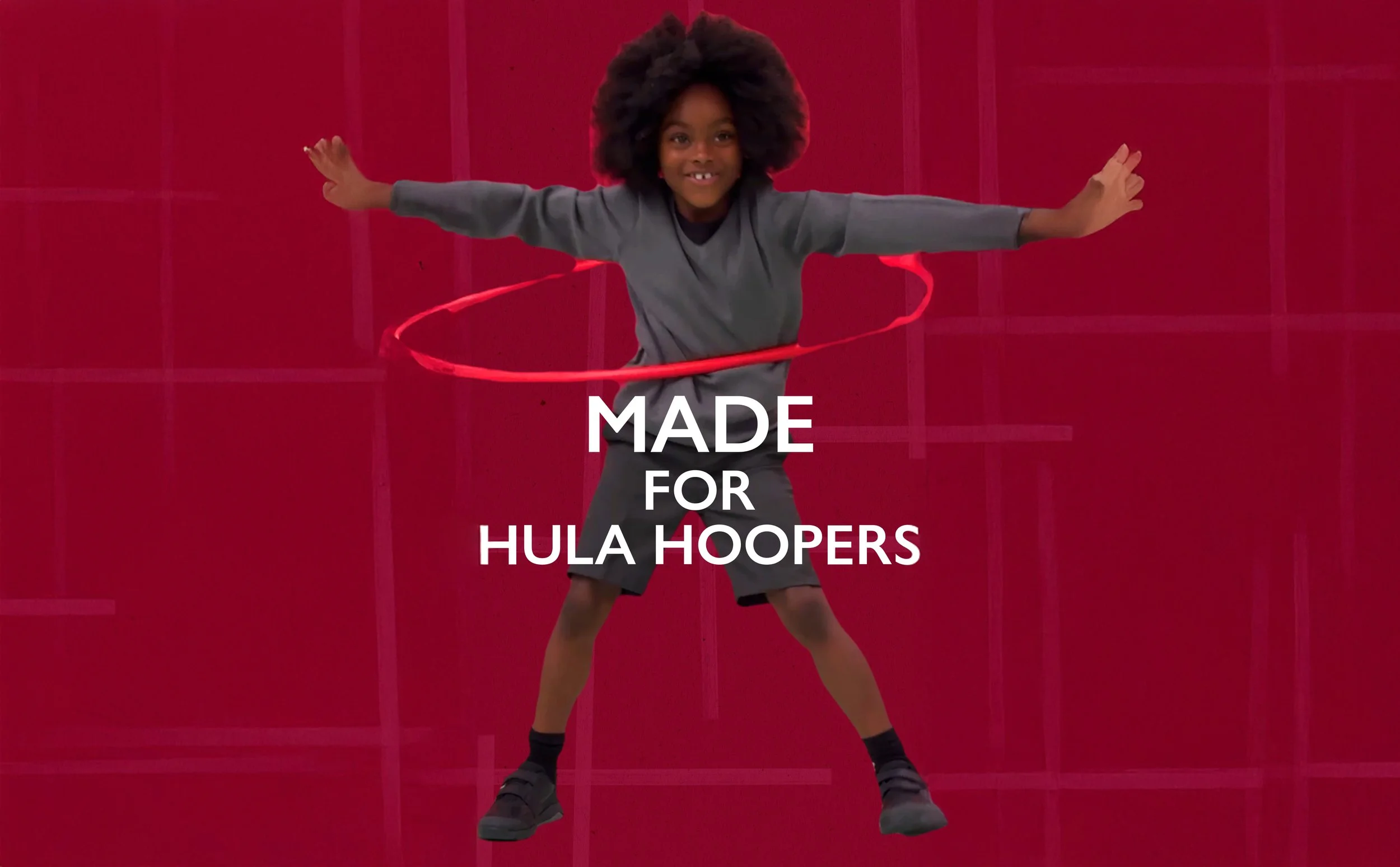 A young girl with curly hair hula hooping in front of a red background, smiling at the camera. Text overlay reads "Made for Hula Hoopers."