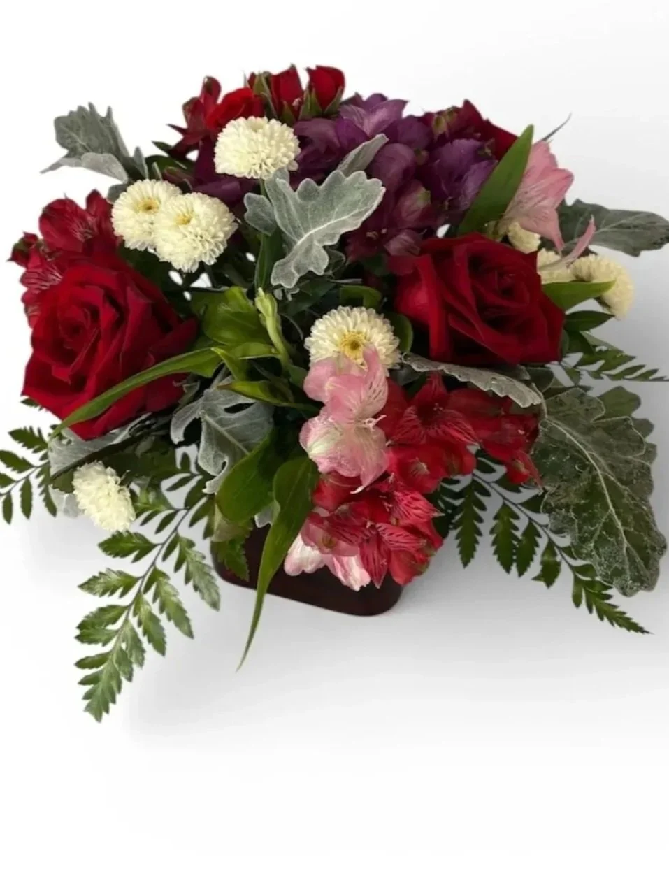 Red roses, white buttons, purple alstroemeria in a red glass cube vase