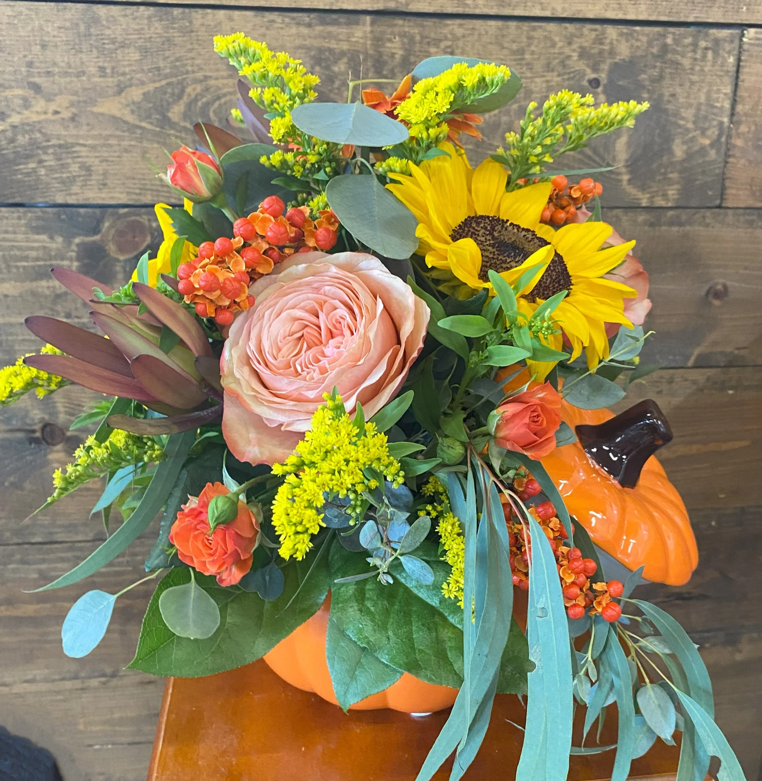 Pumpkin with fresh flowers including sunflowers and eucalyptus