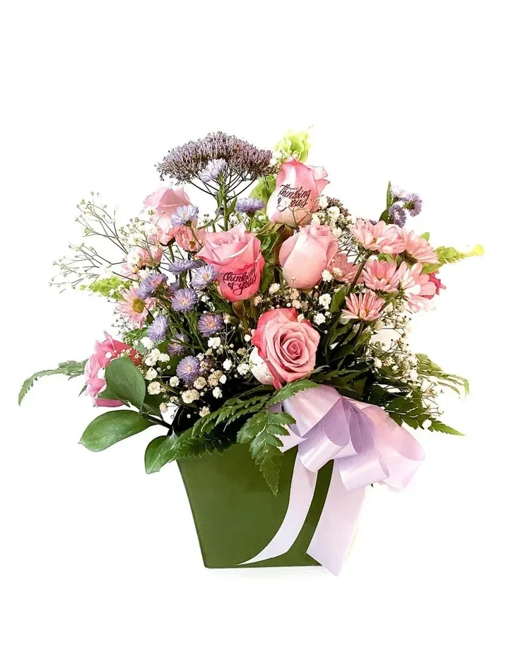 Pink roses, white flowers and baby's breath in green container