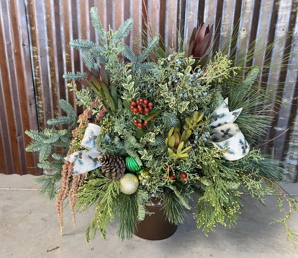 Fresh evergreens and holiday decor in a copper pail