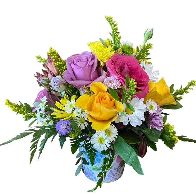 A spring mix of flowers arranged in a container