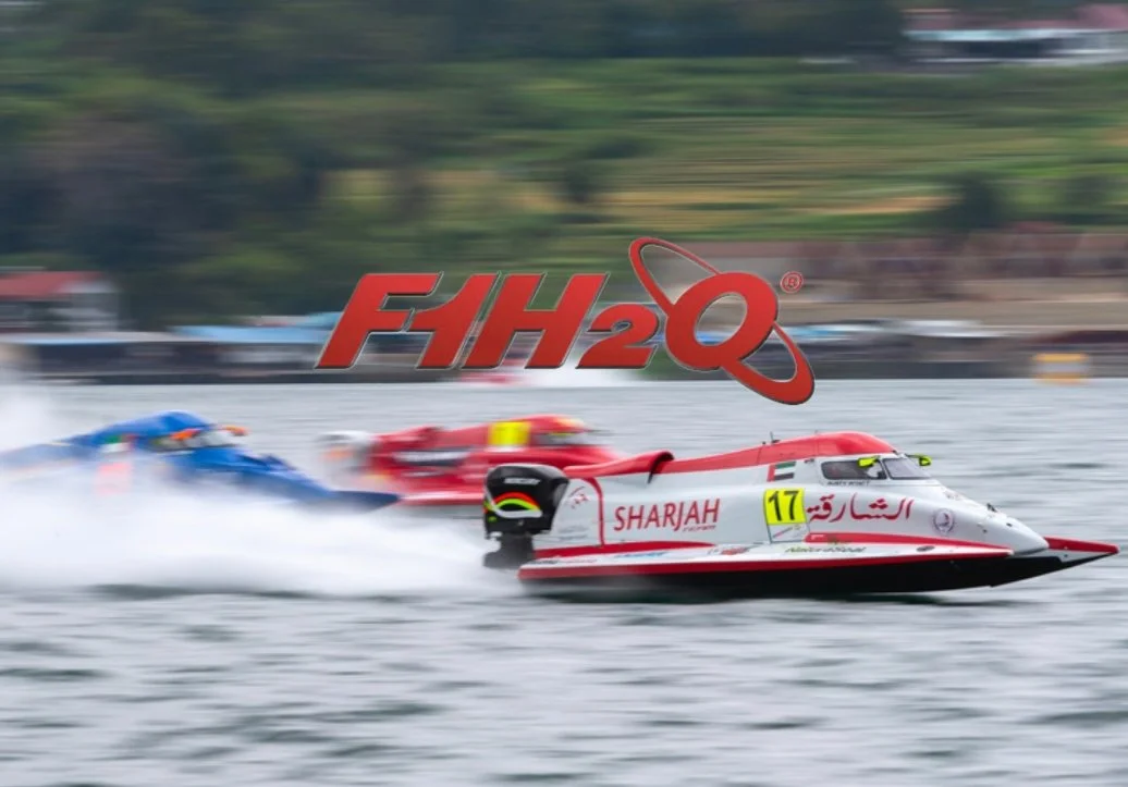 Speedboat racing on a body of water with a logo saying FIH2Q in the foreground and two other speedboats trailing behind.