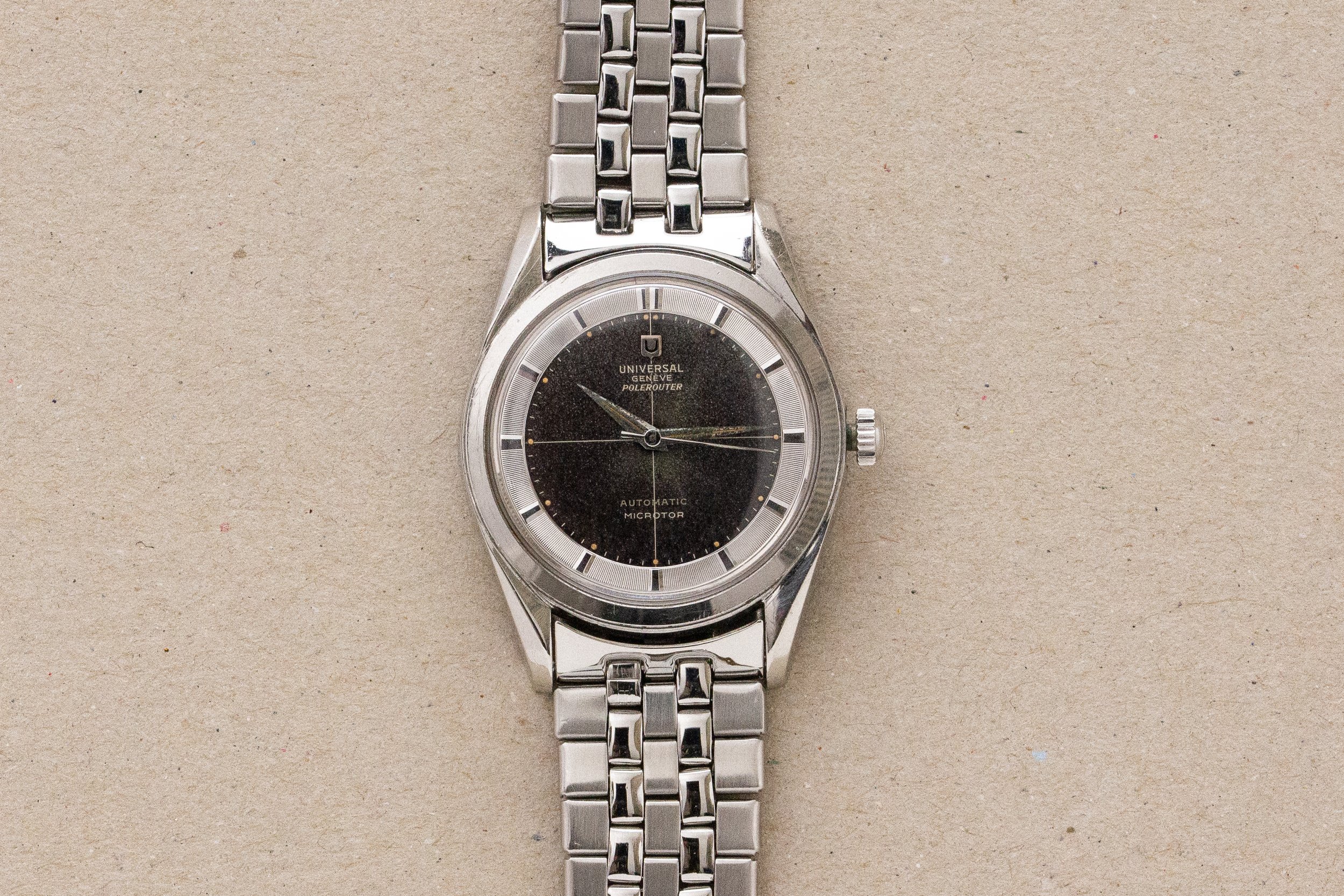 Montre bracelet Universal Geneve polerouter à cadran noir en acier avec son bracelet acier d’époque 1960