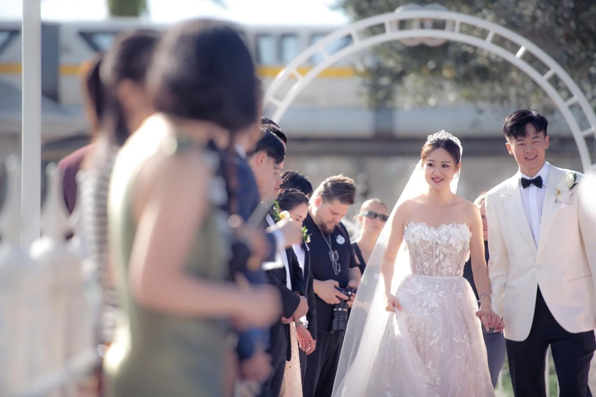 Bride and groom smiling and holding hands during their wedding ceremony outdoors at Disney's Wedding Pavilion.