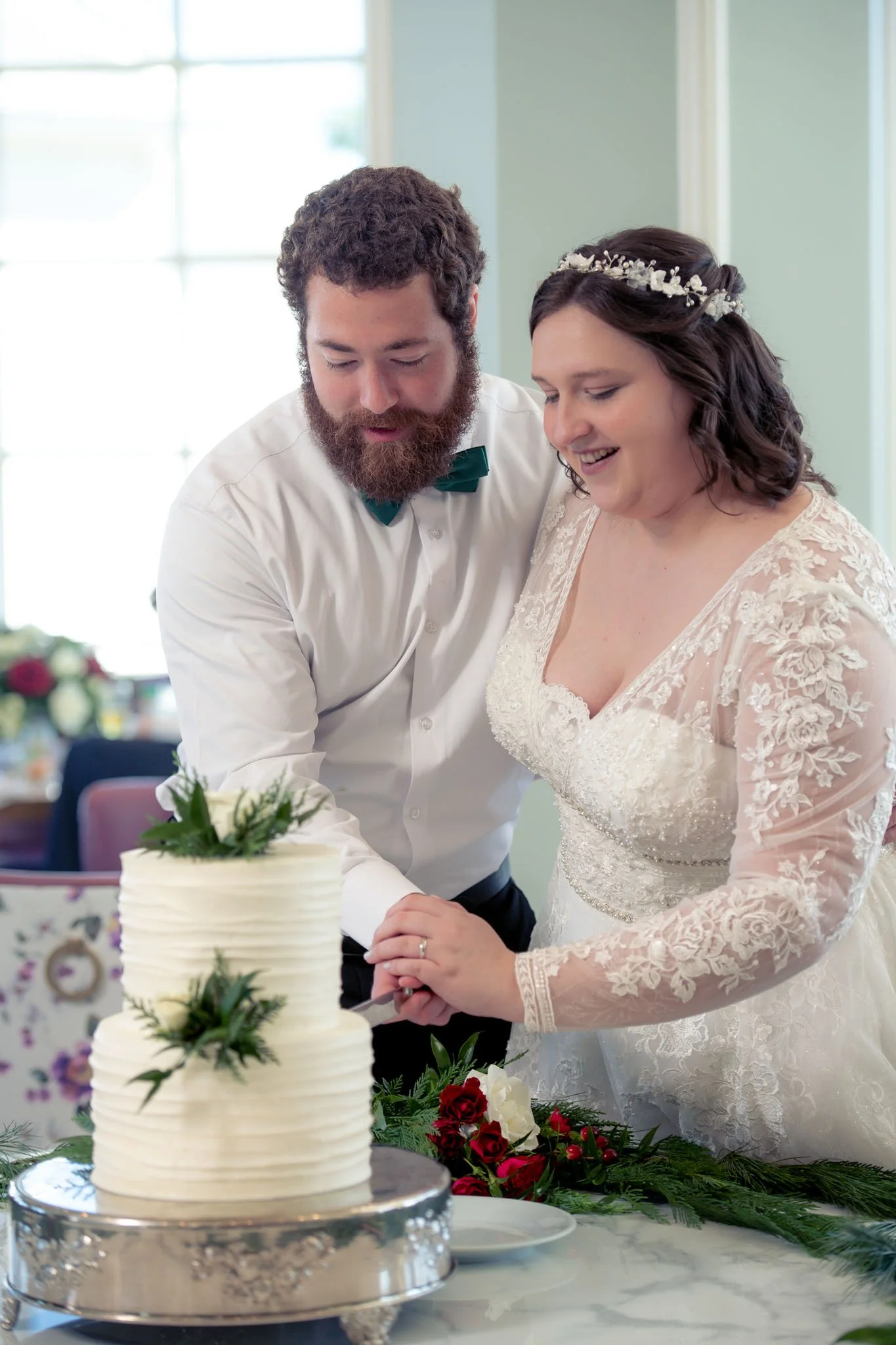 A bride and groom cutting a wedding cake together at their wedding reception.