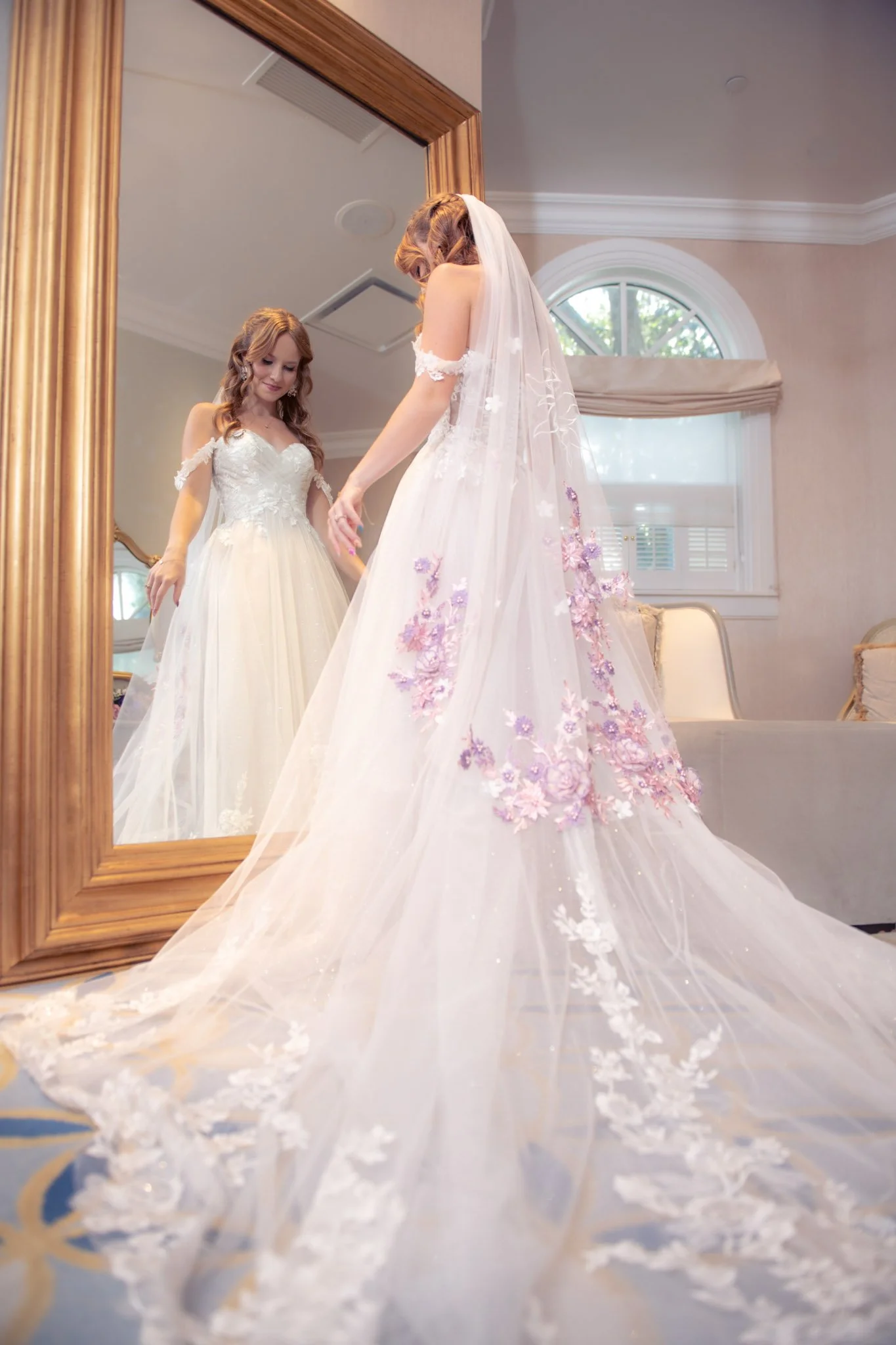 A bride trying on a wedding dress in front of a mirror at Disney's Wedding Pavilion.