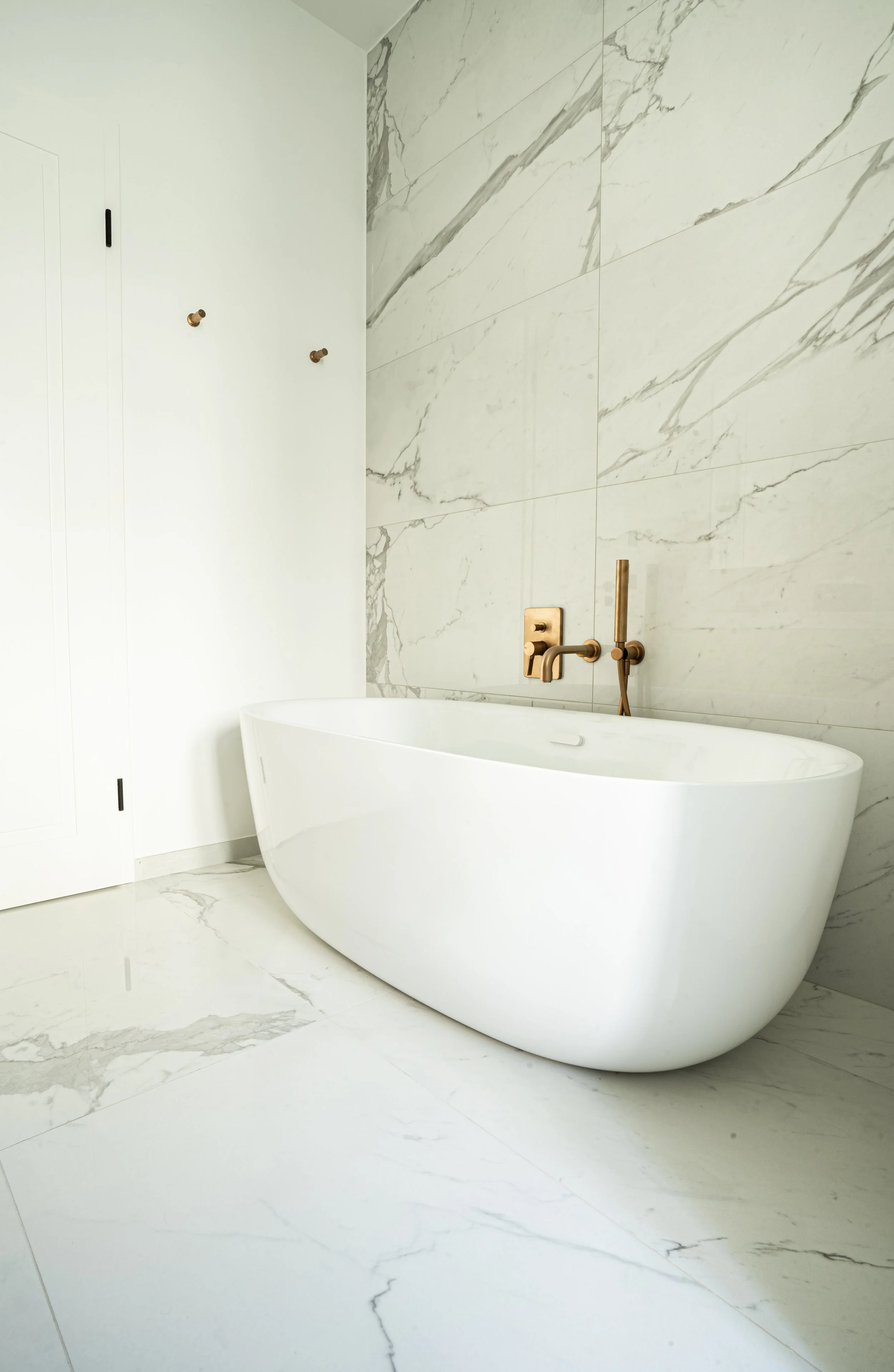 Une salle de bain moderne avec une baignoire white et un mur en carrelage marbré