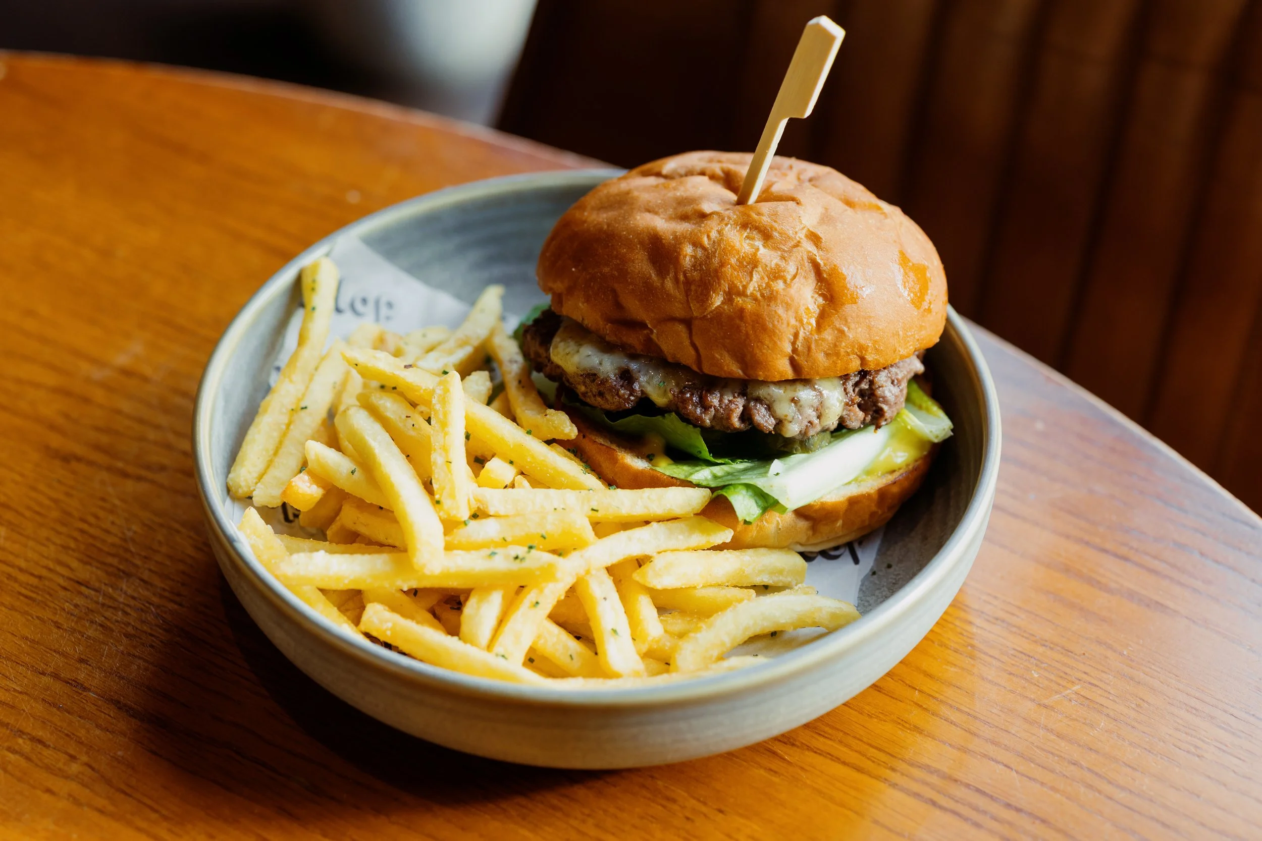 Smashed dry-aged beef, monterey jack cheese and lettuce in a brioche bun and chips at Wallop