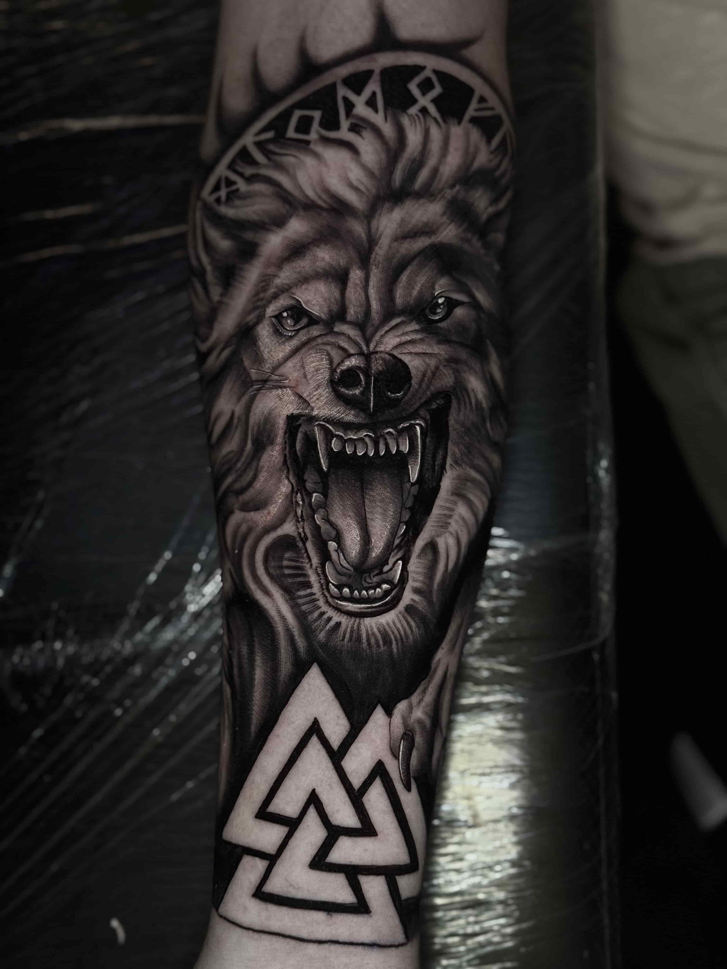 black and grey realism wolf with nordic inspiration tattoo