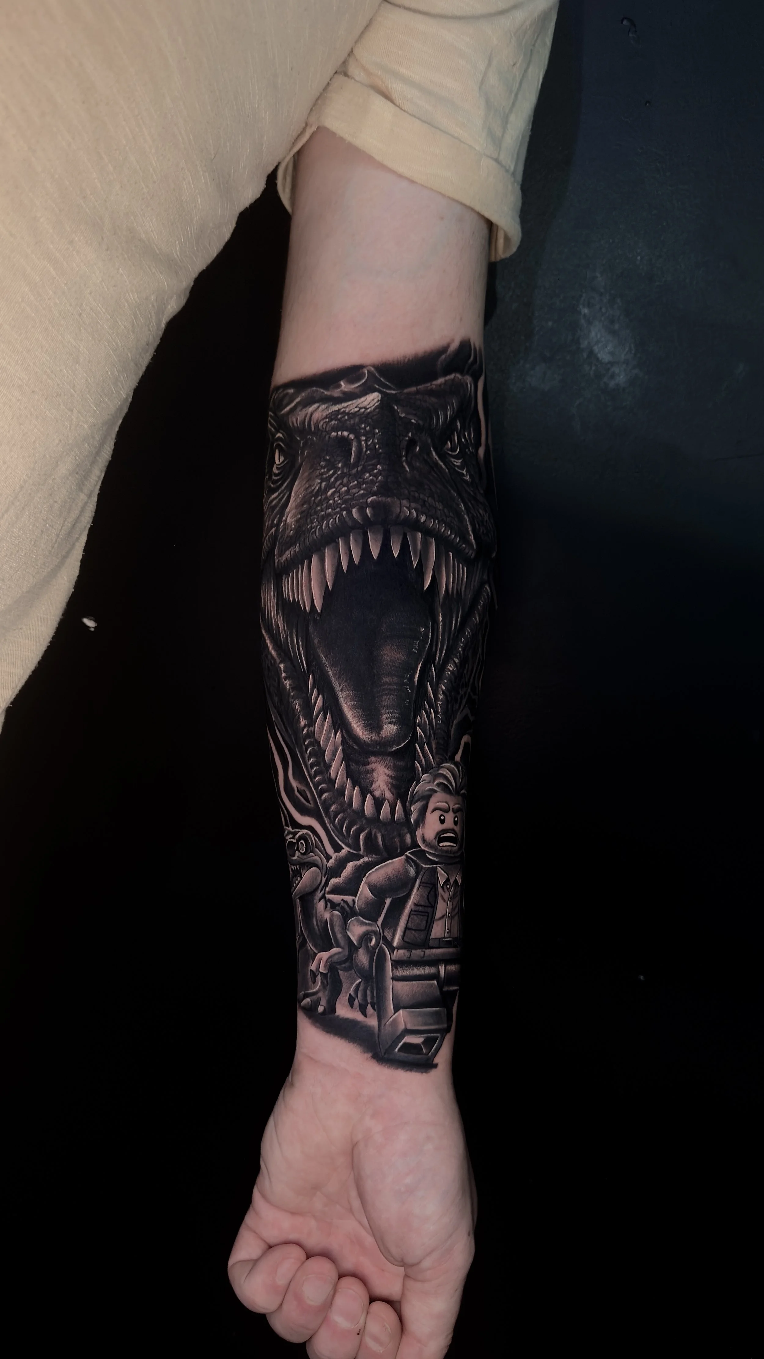 Black and grey realistic dinosaur and lego jurassic inspired tattoo, by Harry Devlin, Devlin Ink Tattoos Colchester