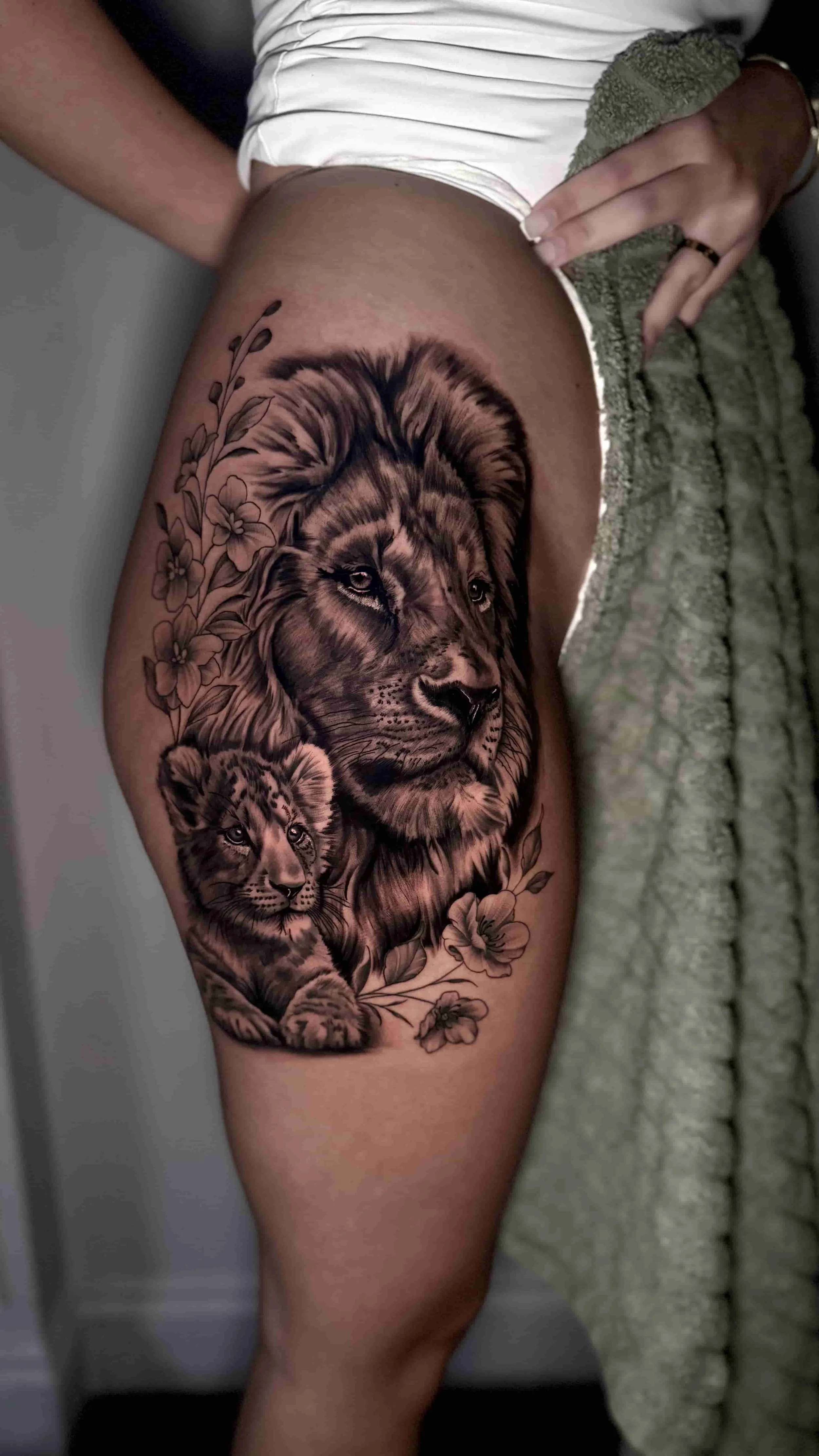 Black and grey realism of a lion and cub tattoo