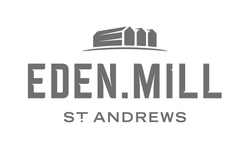 Logo of Eden Mill St. Andrews featuring a stylized building or warehouse above the text.
