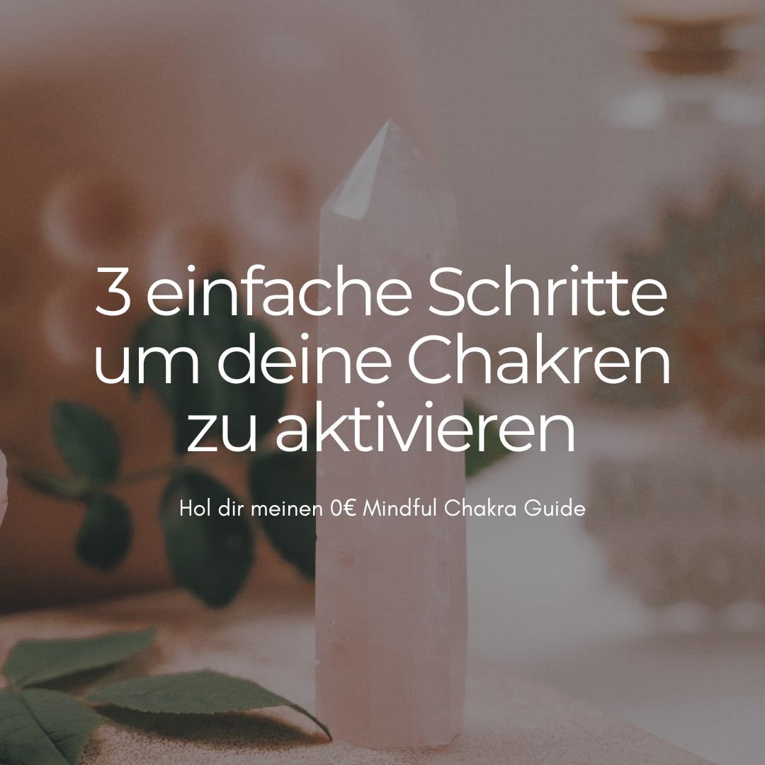 Ein Heilstein auf einem weißen Untergrund, umgeben von grünen Blättern, im Hintergrund sind unscharfe weiße Kristalle.