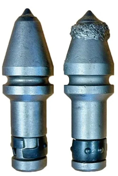 Close up of metal drilling auger teeth, the C31 XHD tooth and the B47K XHD tooth.