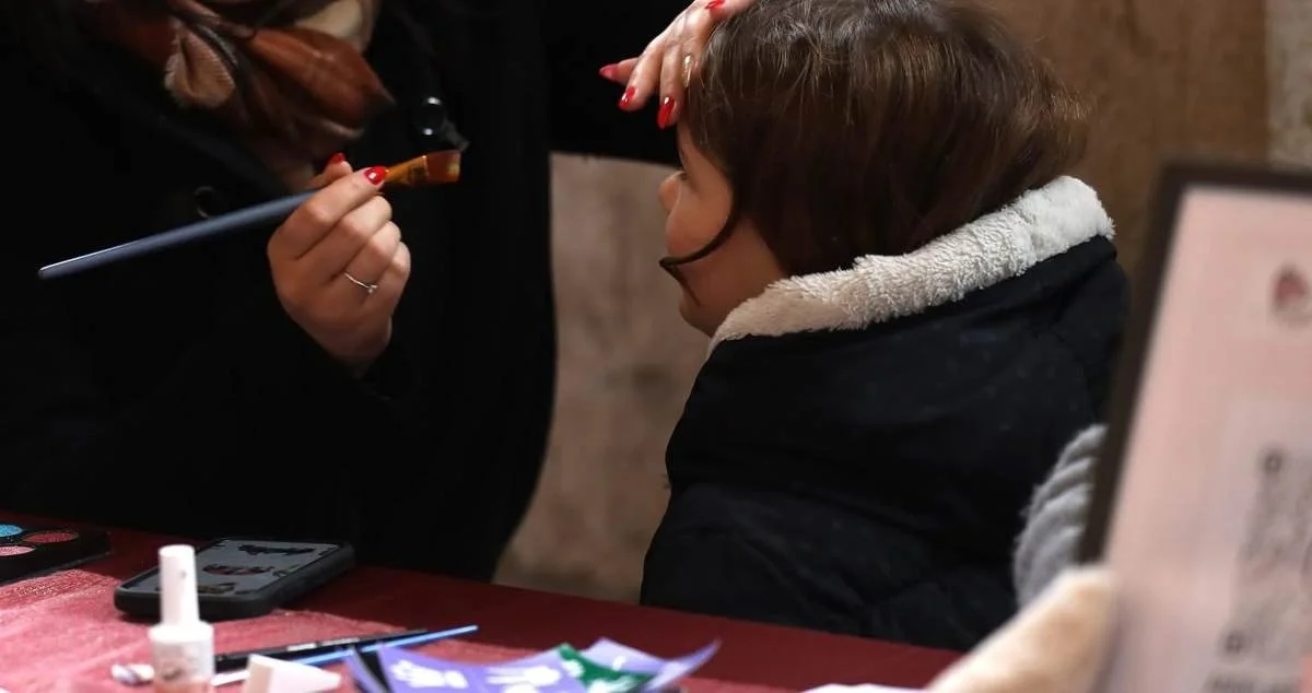 Animation maquillage enfants pour l'UCAB au marché de Noël de Belley (Ain) : la maquilleuse Angel'Art Esthétique maquille un enfant