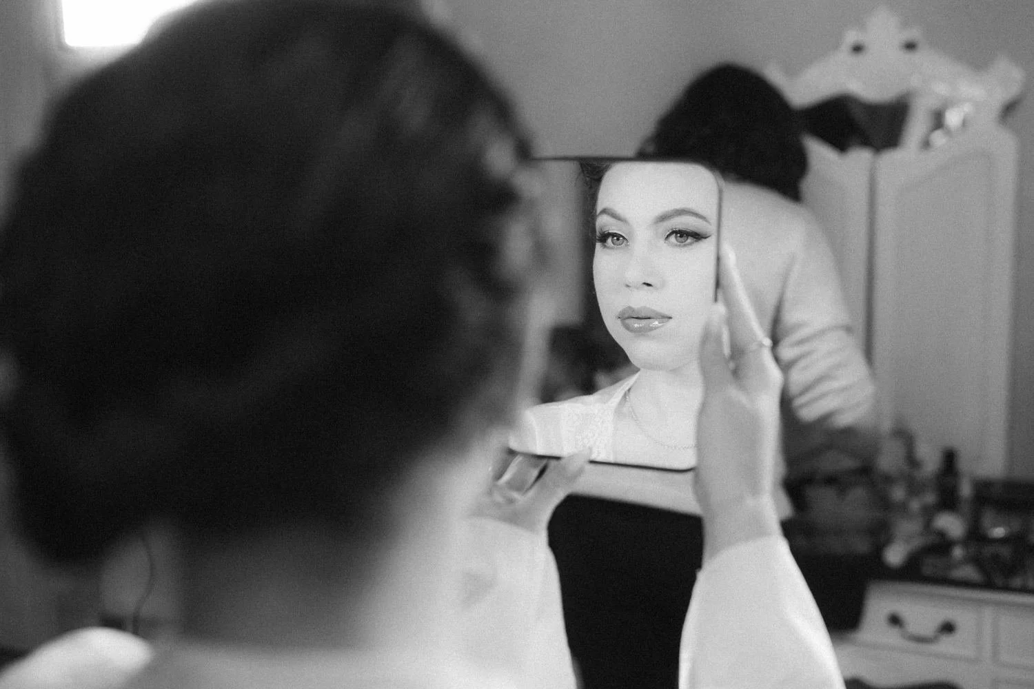 Future mariée découvrant son maquillage dans un miroir lors de son essai maquillage mariée