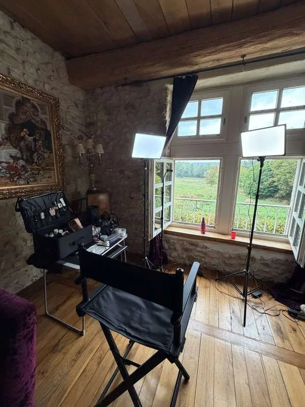 Studio de maquillage mariée à domicile : éclairage LED, fauteuil et mallette de maquilleuse près d'une fenêtre