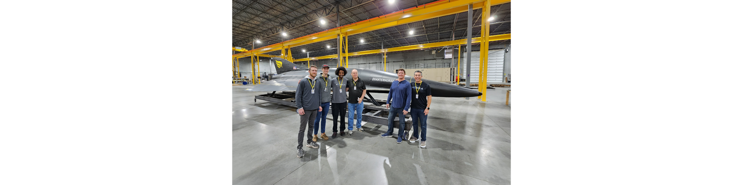  Atomic-6 team poses with Hermeus CTO, Glenn Case, in front of their Quarterhorse aircraft. 