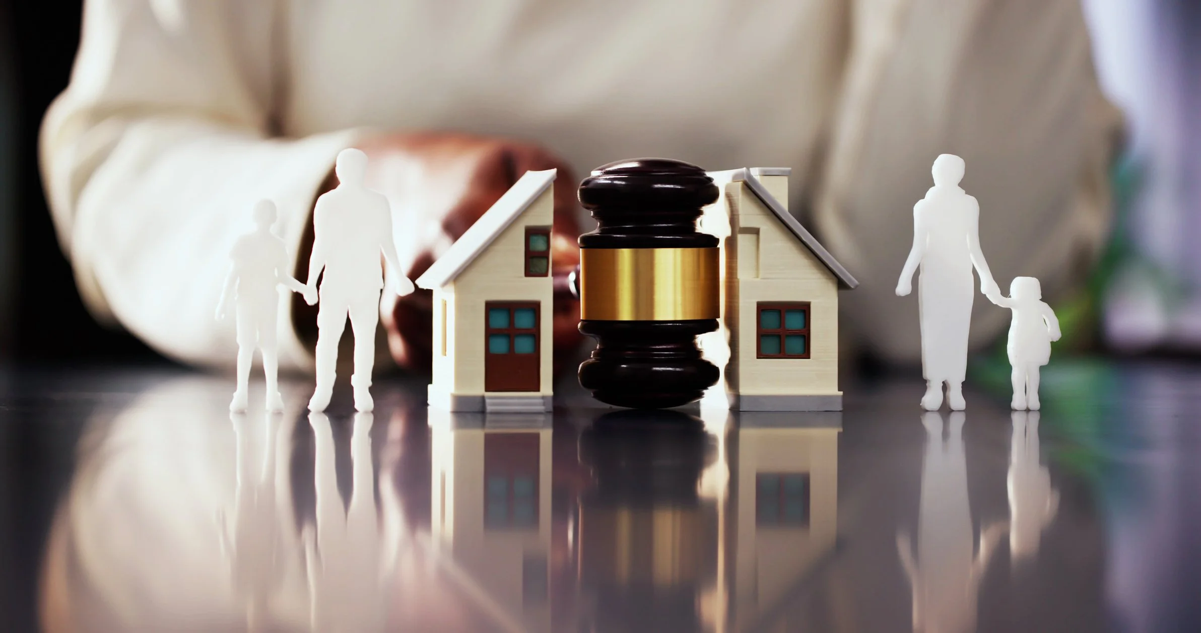 Illustration of a house divided into two halves with a judge's gavel between them, representing property valuation during divorce and separation.