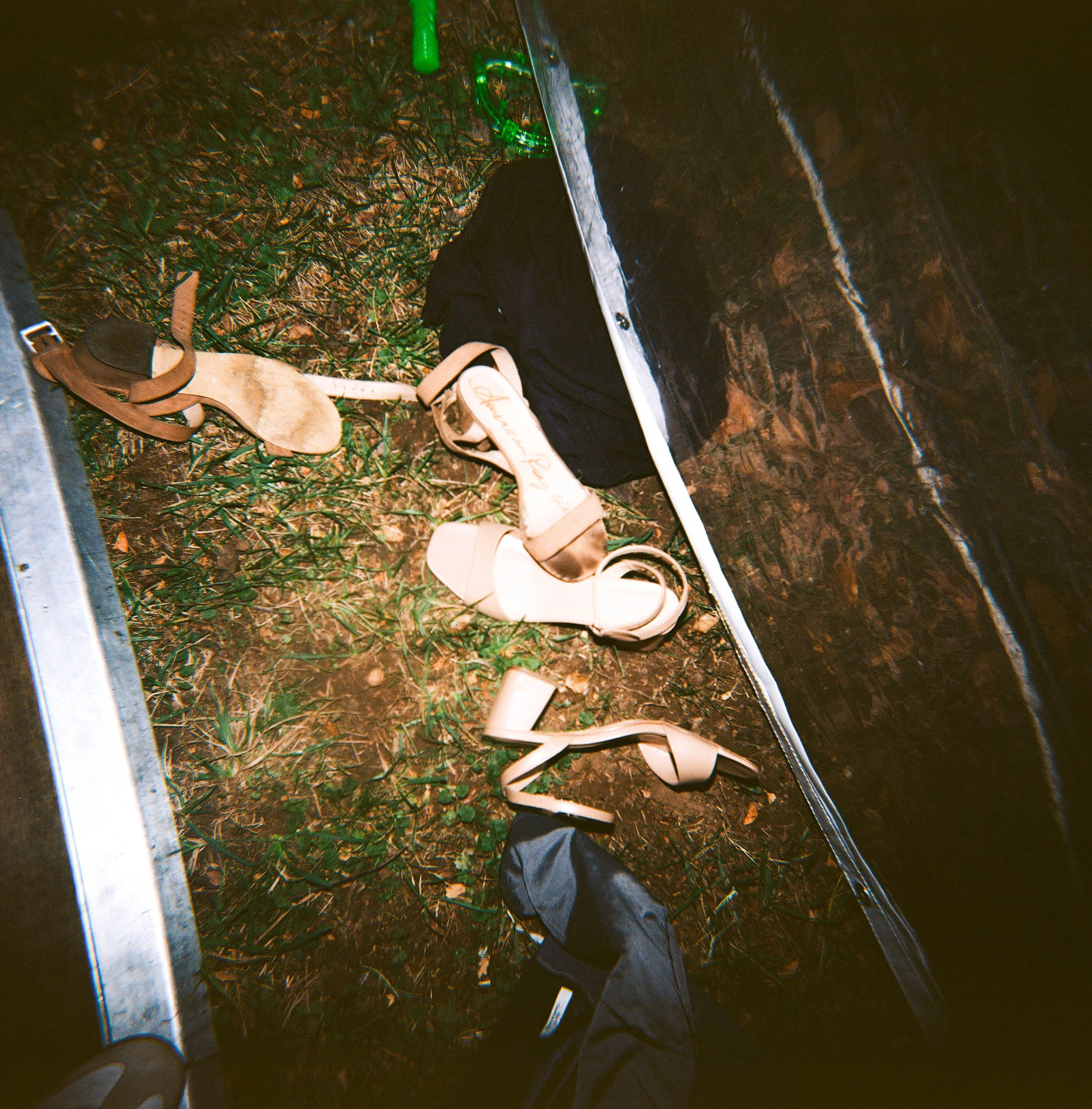 Women’s shoes on the ground next to a black sock inside a tent.